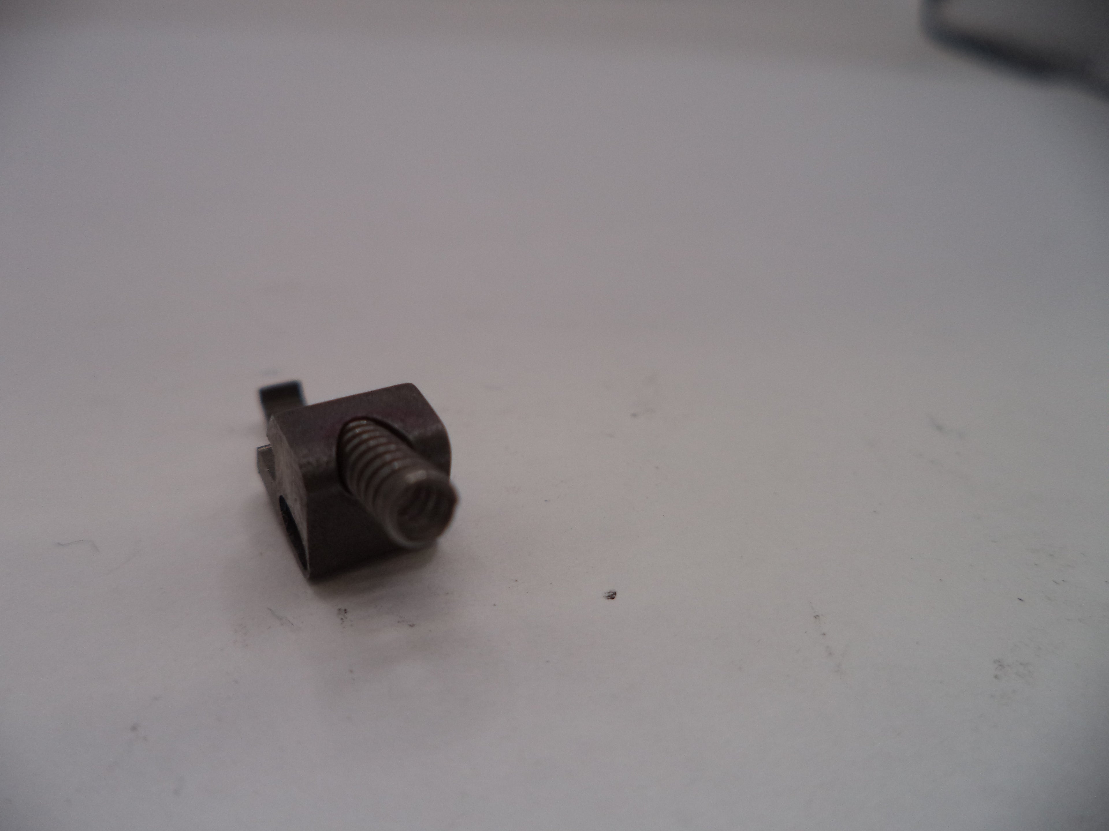 Small metal screw on a white surface