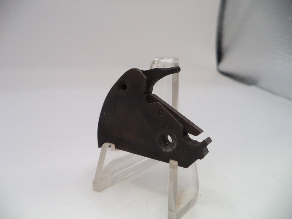 Black metal component on a clear stand against a white background