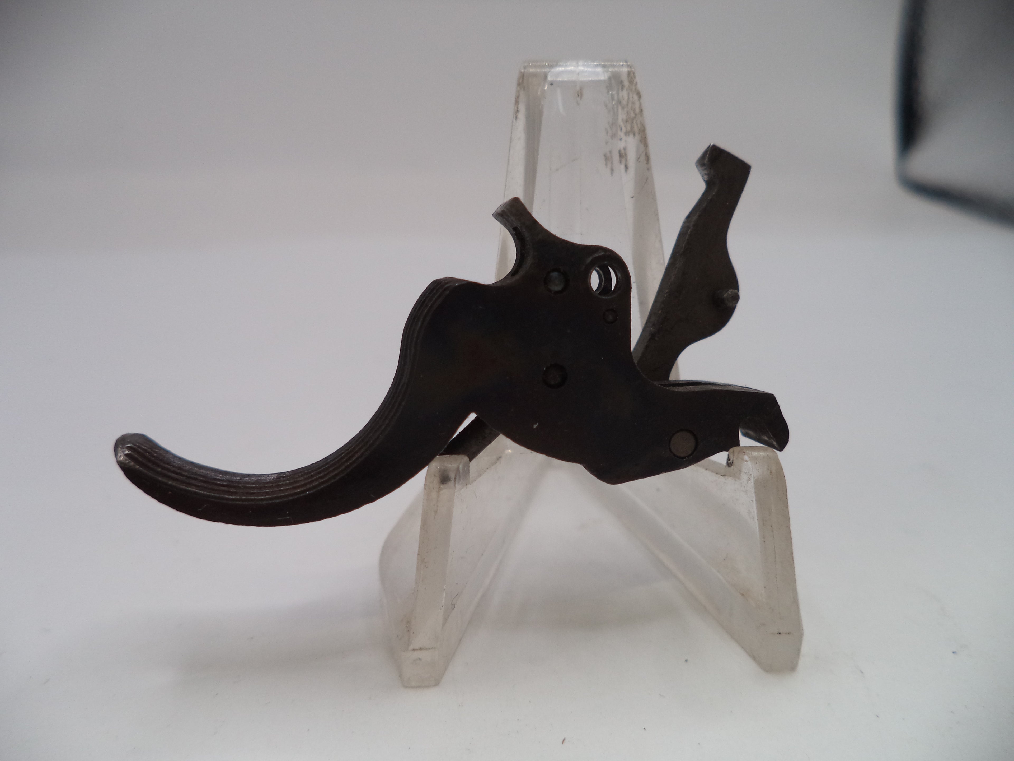 Black metal lever on a clear plastic stand against a white background