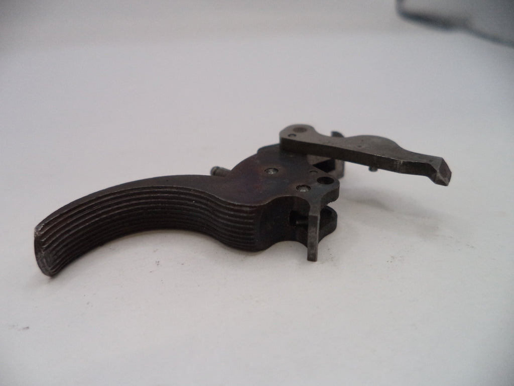 Metallic firearm trigger on a white surface