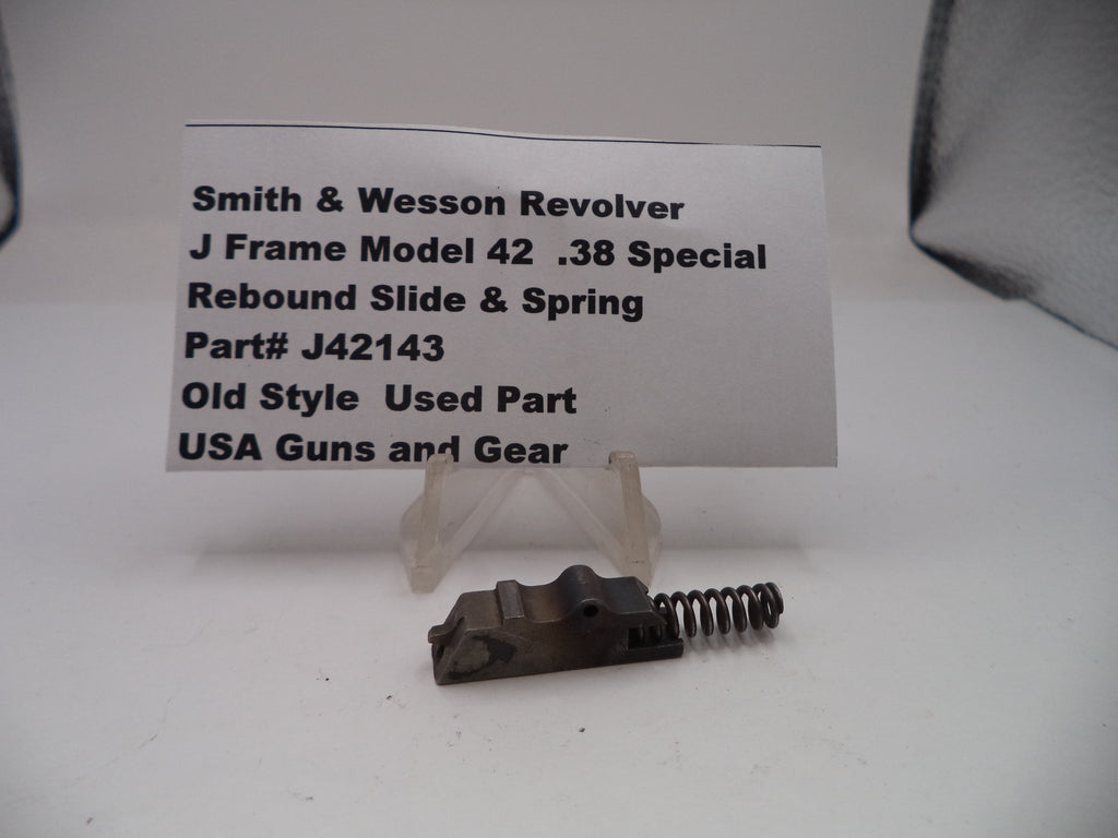 Smith & Wesson revolver slide and spring with a label on a white background