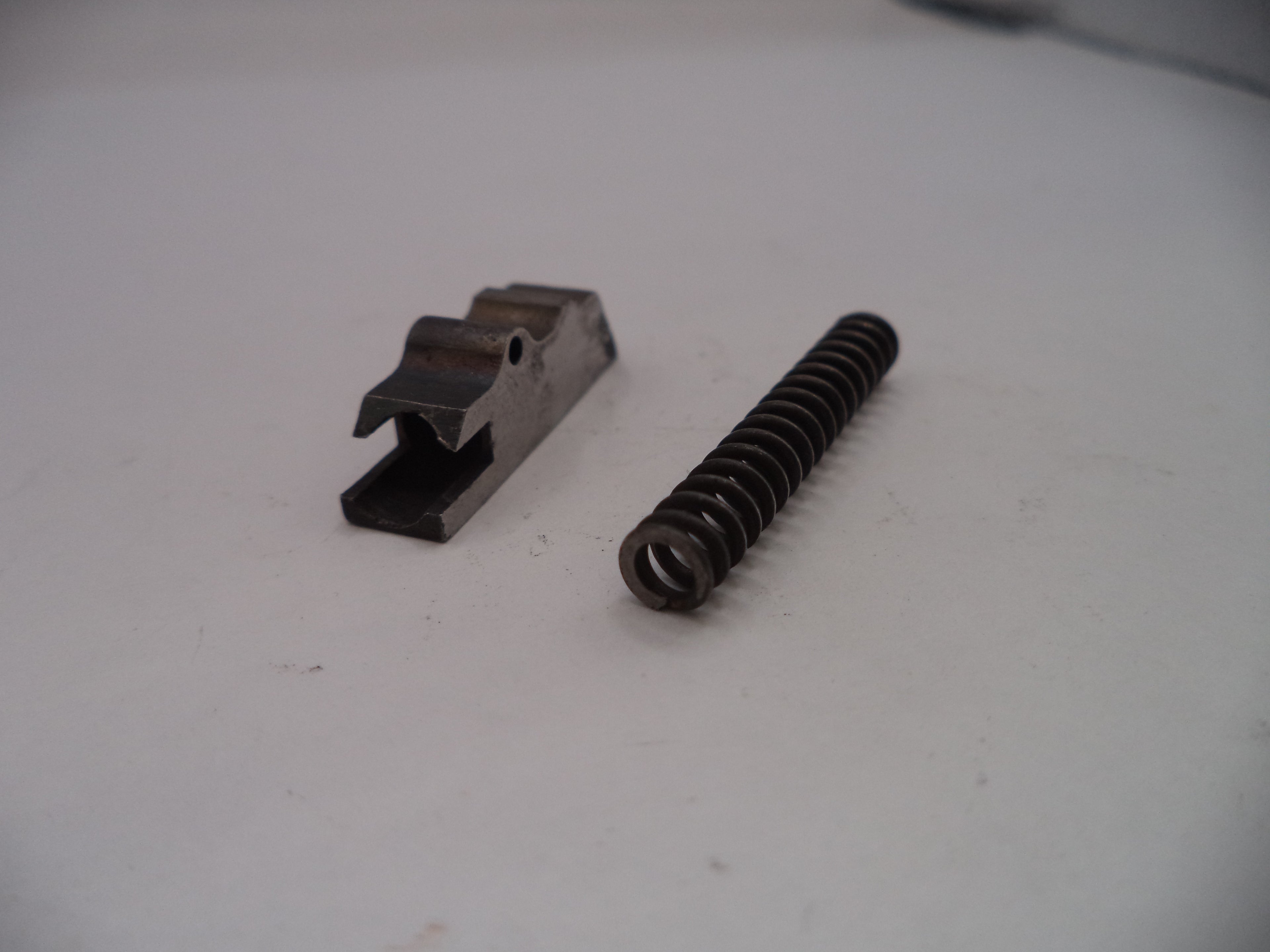 Metal spring and metal component on a white surface