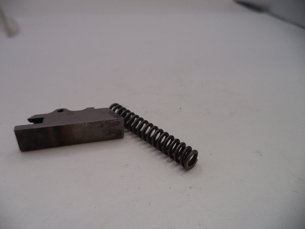 Metal component with a spring on a white surface