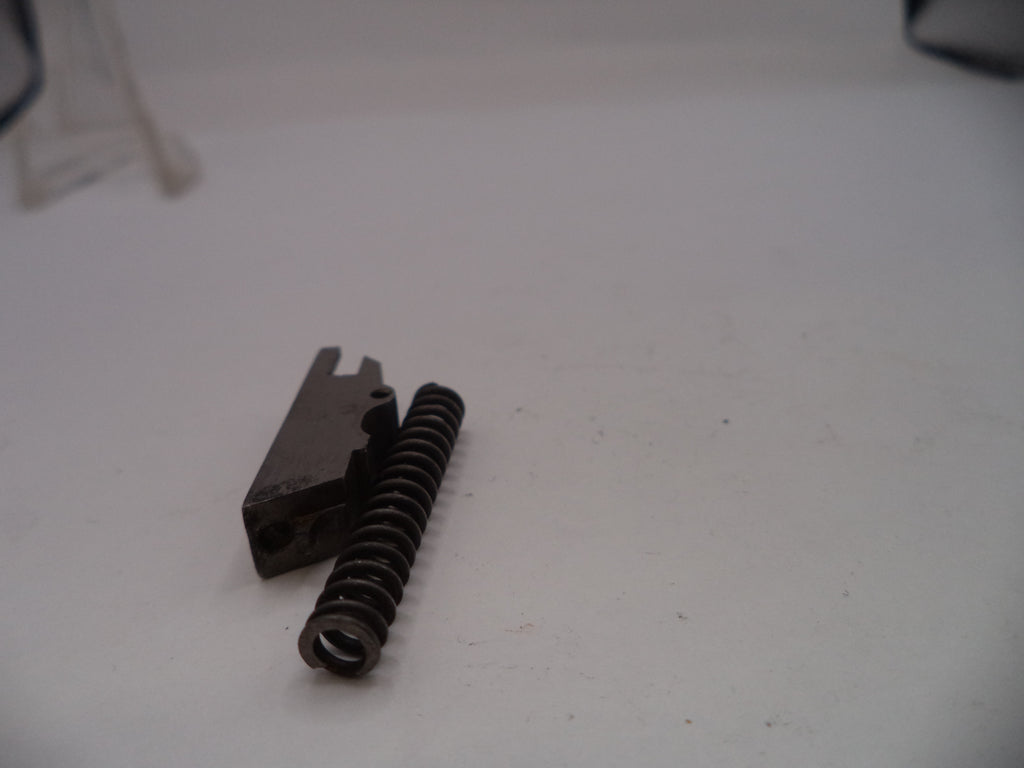 Metal spring and component on a white surface