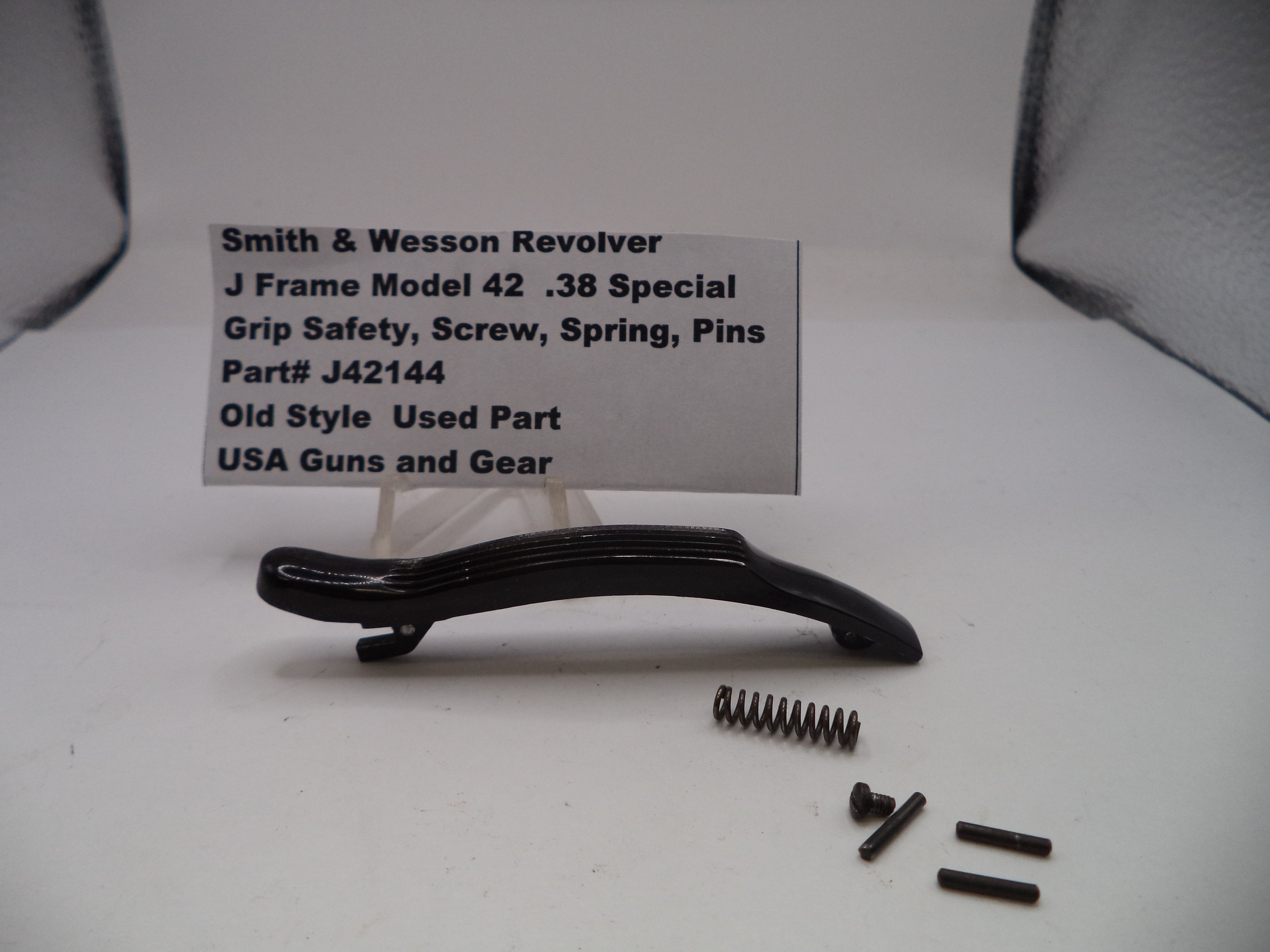 Smith & Wesson revolver part with screws and spring on a white background