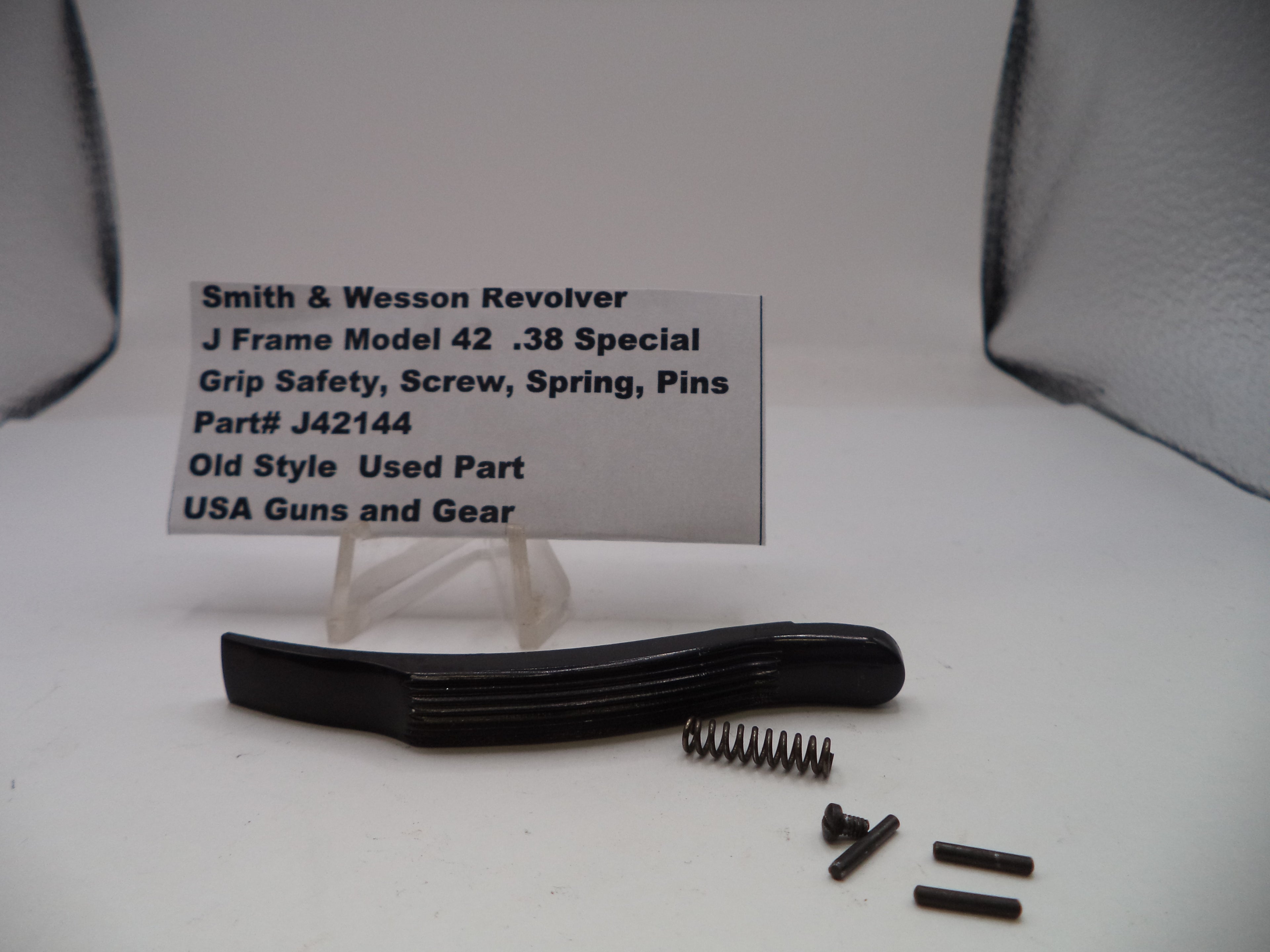 Smith & Wesson revolver parts including a grip safety, screw, spring, and pins on a white background with a label.