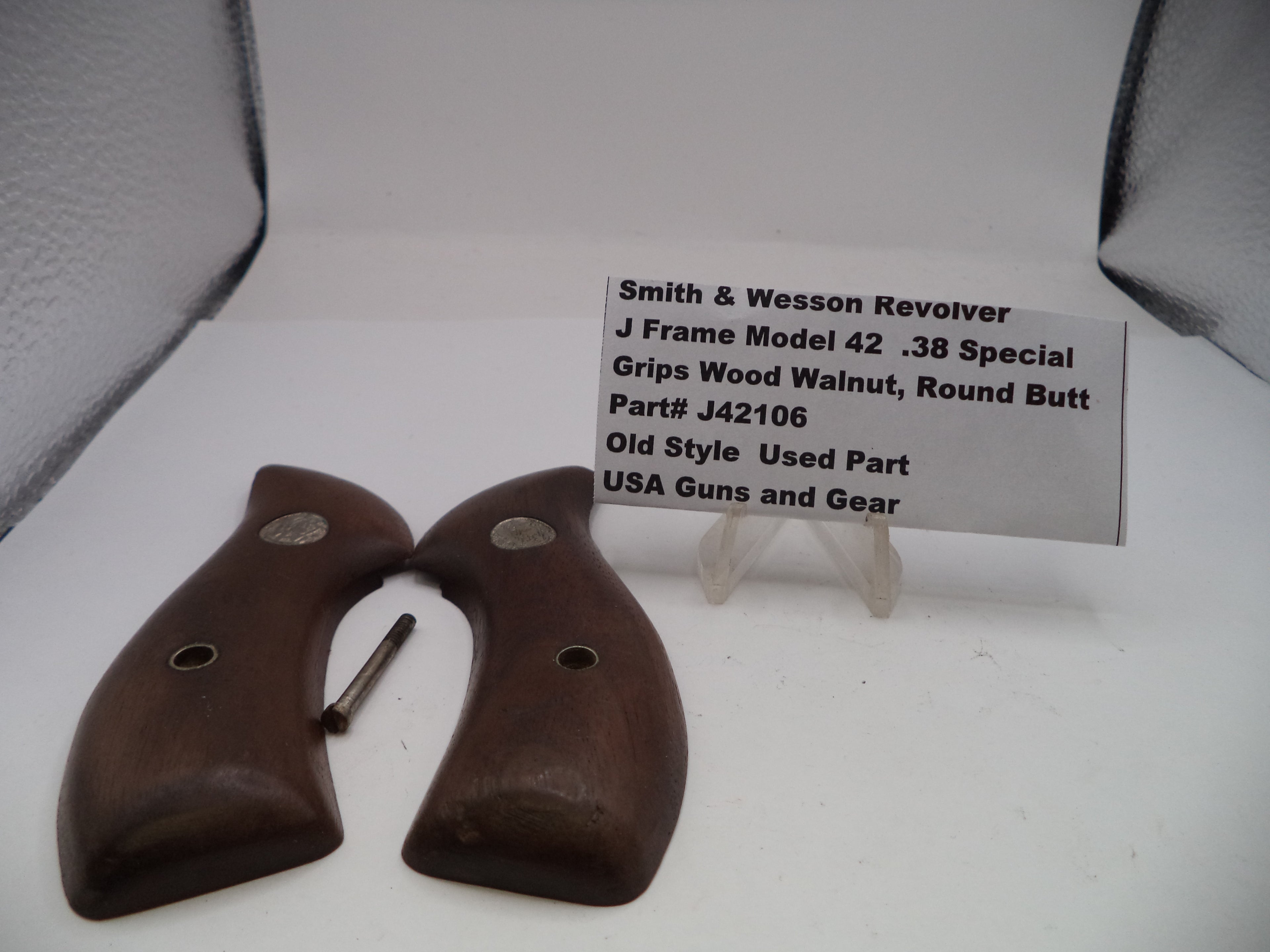 Wooden gun grips with a label on a white surface