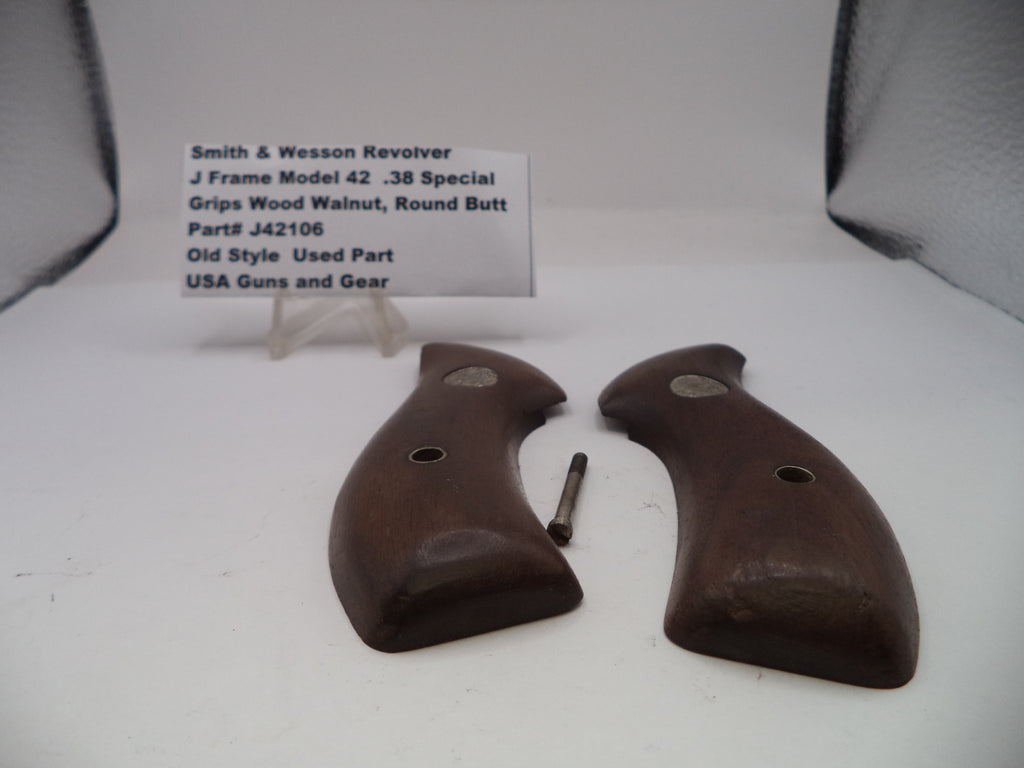 Pair of brown gun grips on a white surface with a label in the background.