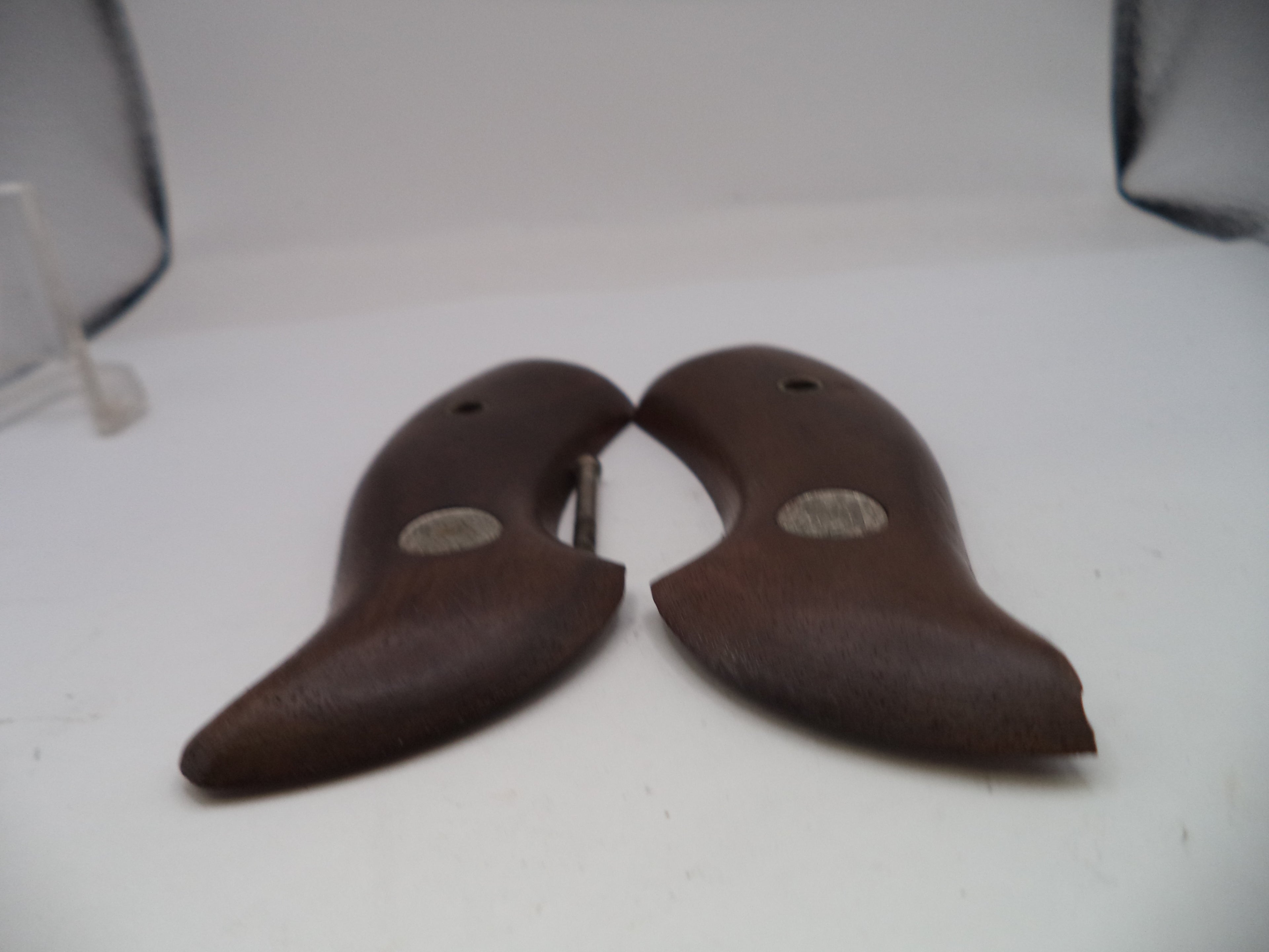 Pair of brown shoe trees on a white surface