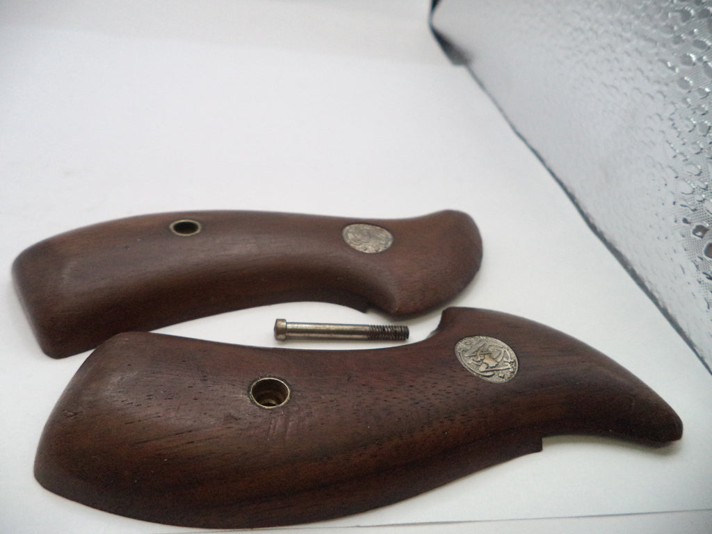 Wooden gun grips with metal pins on a white surface