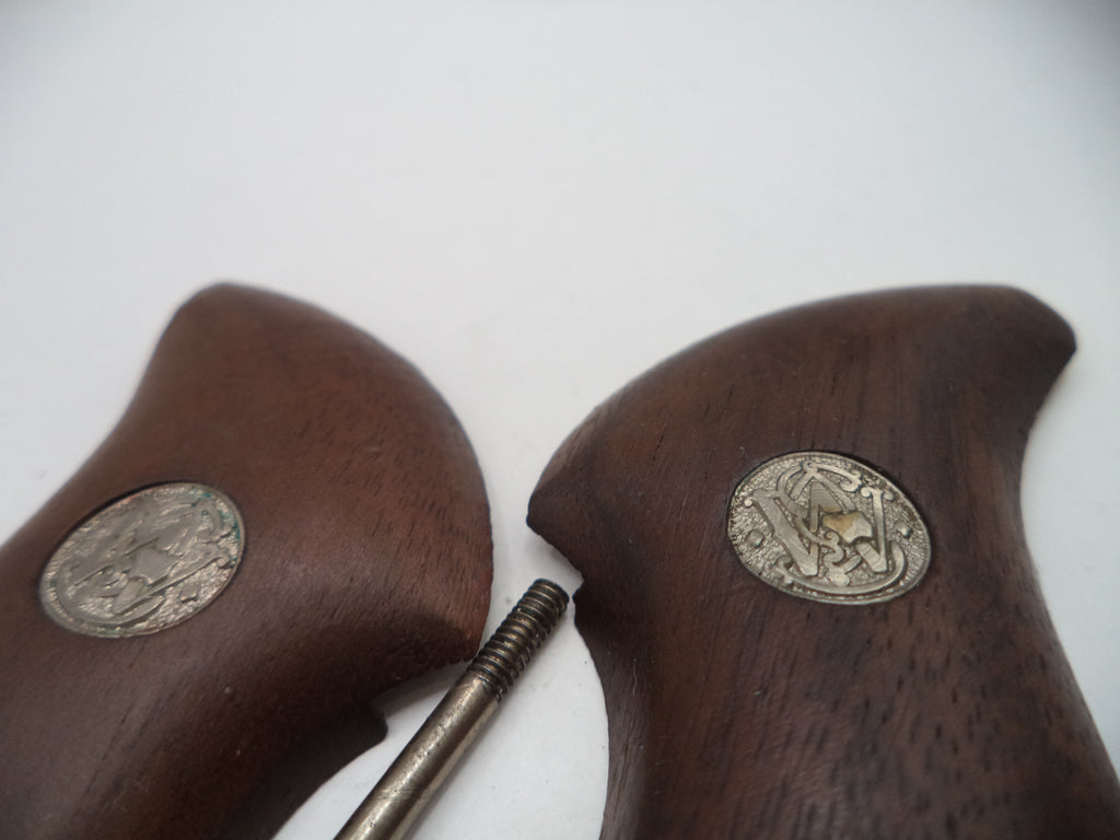 Wooden gun grips with metal coins embedded on a white background