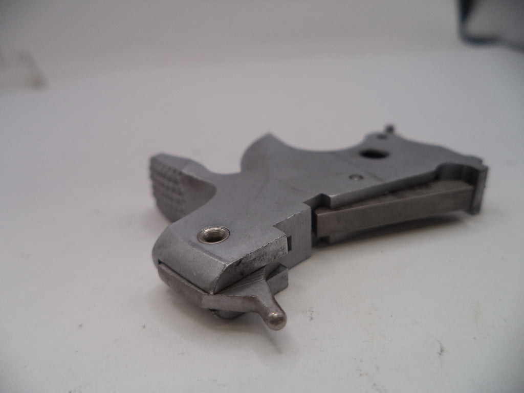 Metal gun part on a white surface