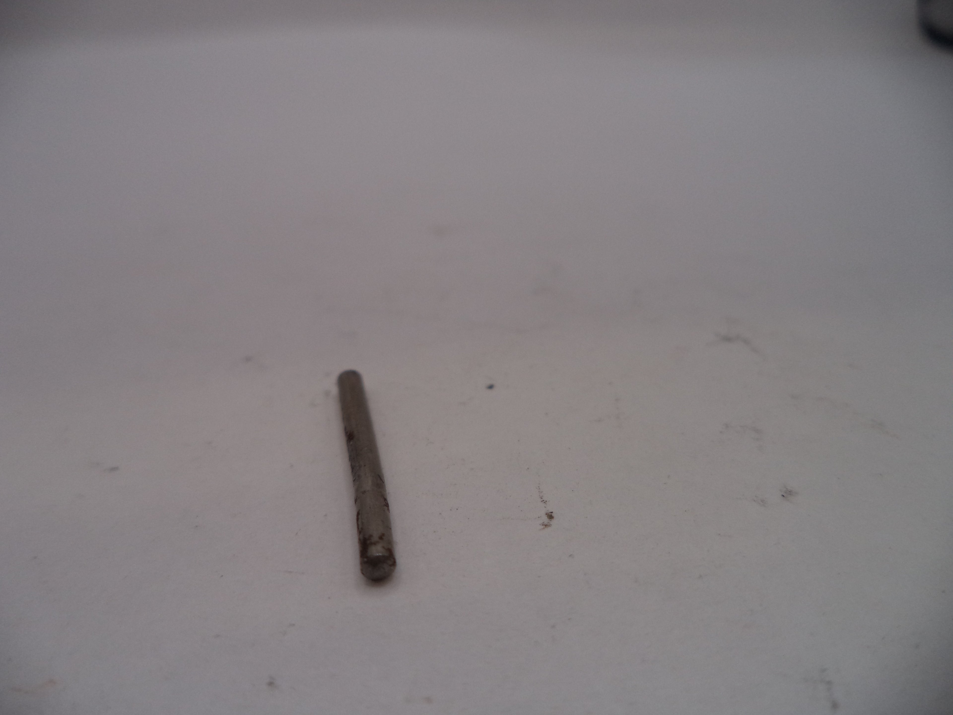 Small metal rod on a white surface