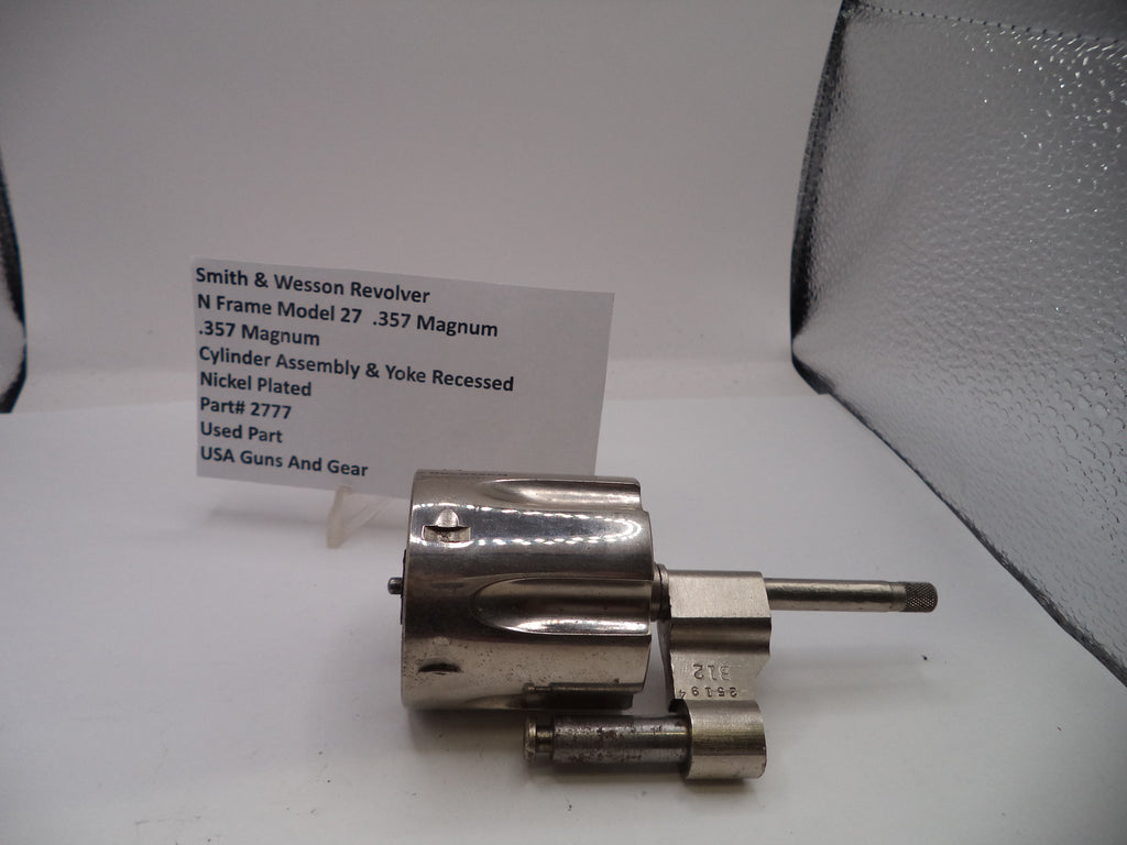 Smith & Wesson revolver cylinder on a white surface with a label in the background