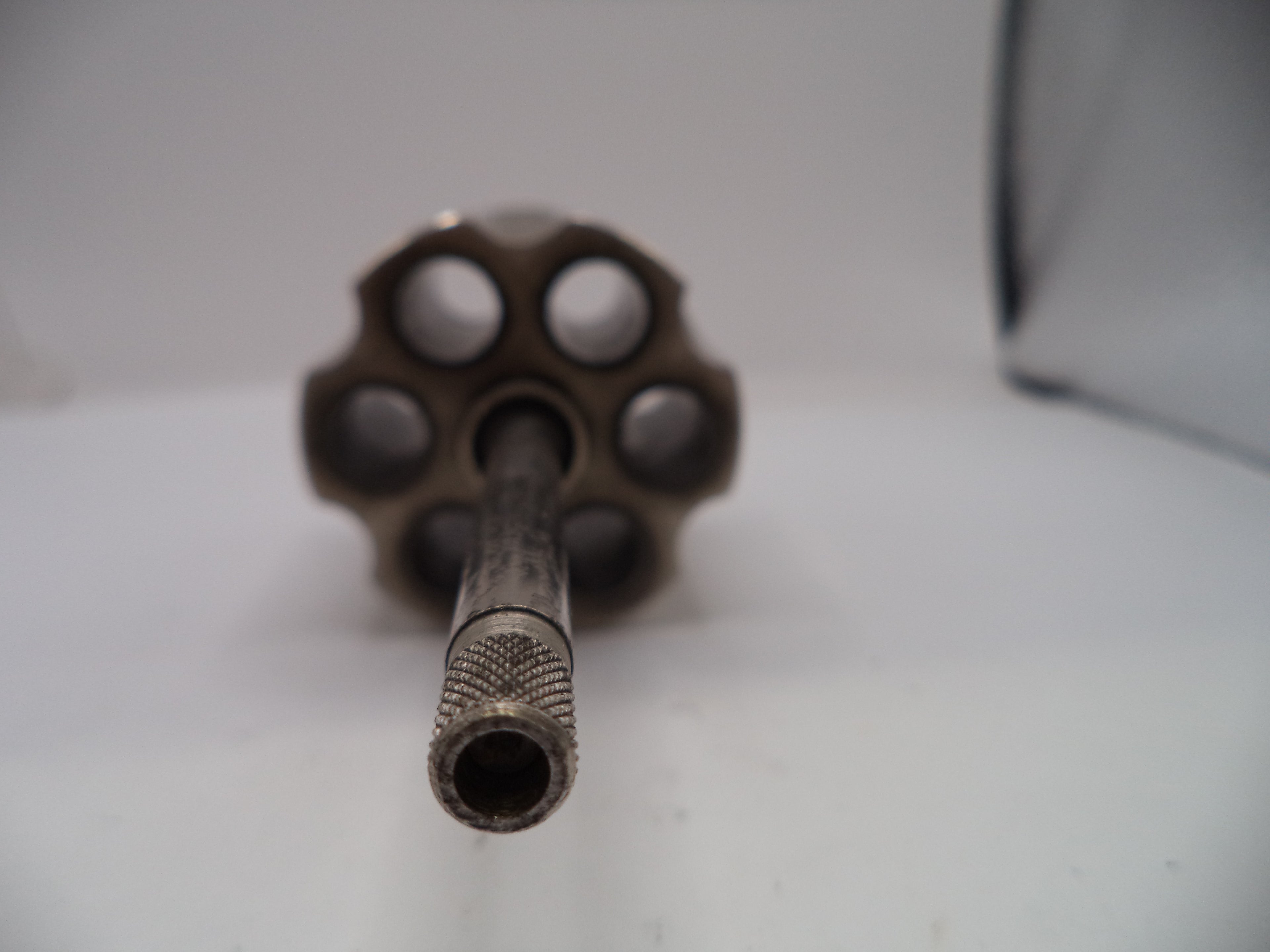 Close-up of a revolver barrel on a white background