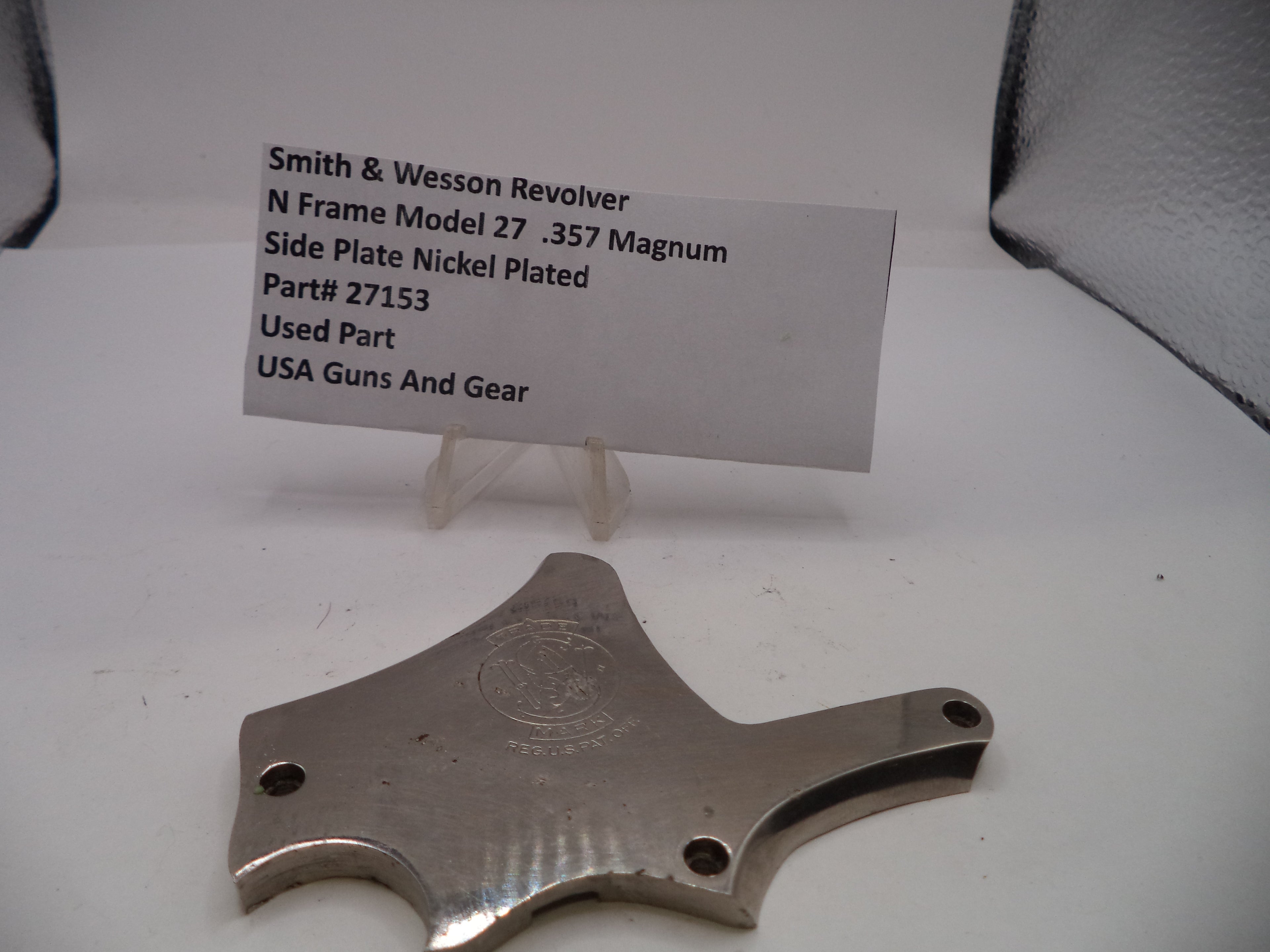 Smith & Wesson revolver side plate on a white background with a label