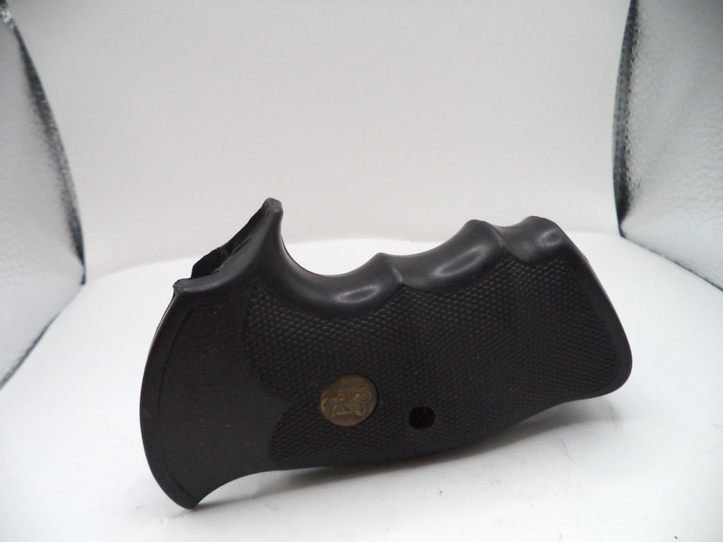 Black gun grip on a white surface with a gray background