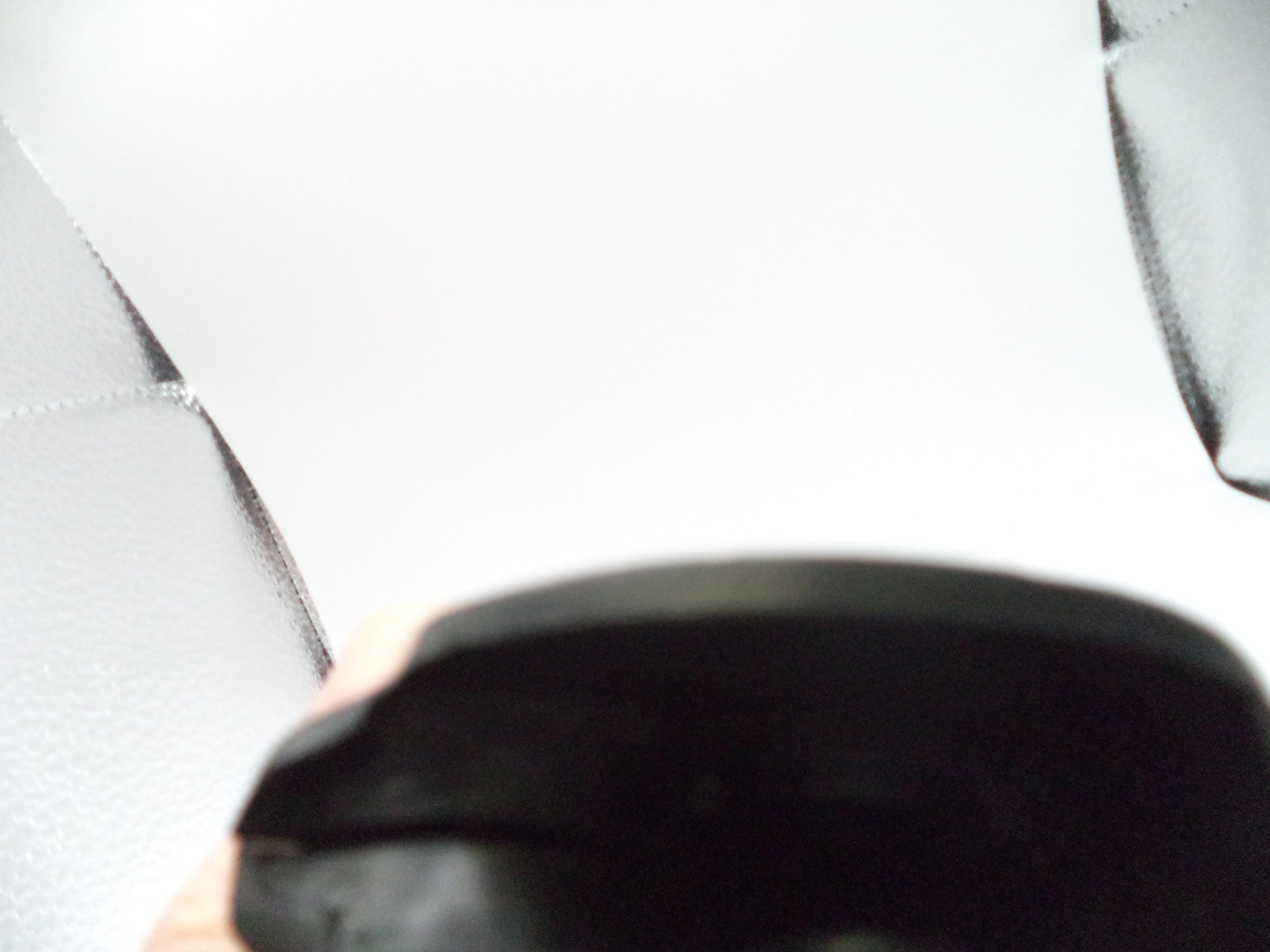 Close-up of a black shoe on a light gray tiled floor