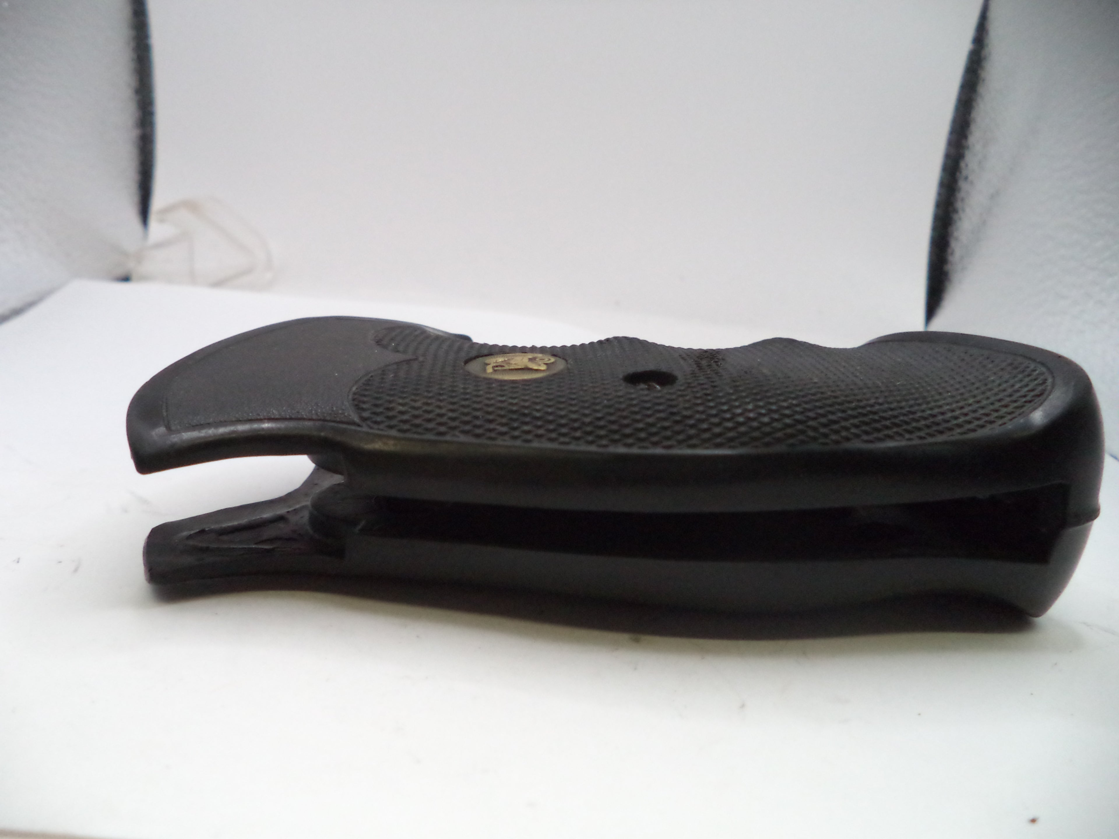 Black rubber gun stock on a white surface