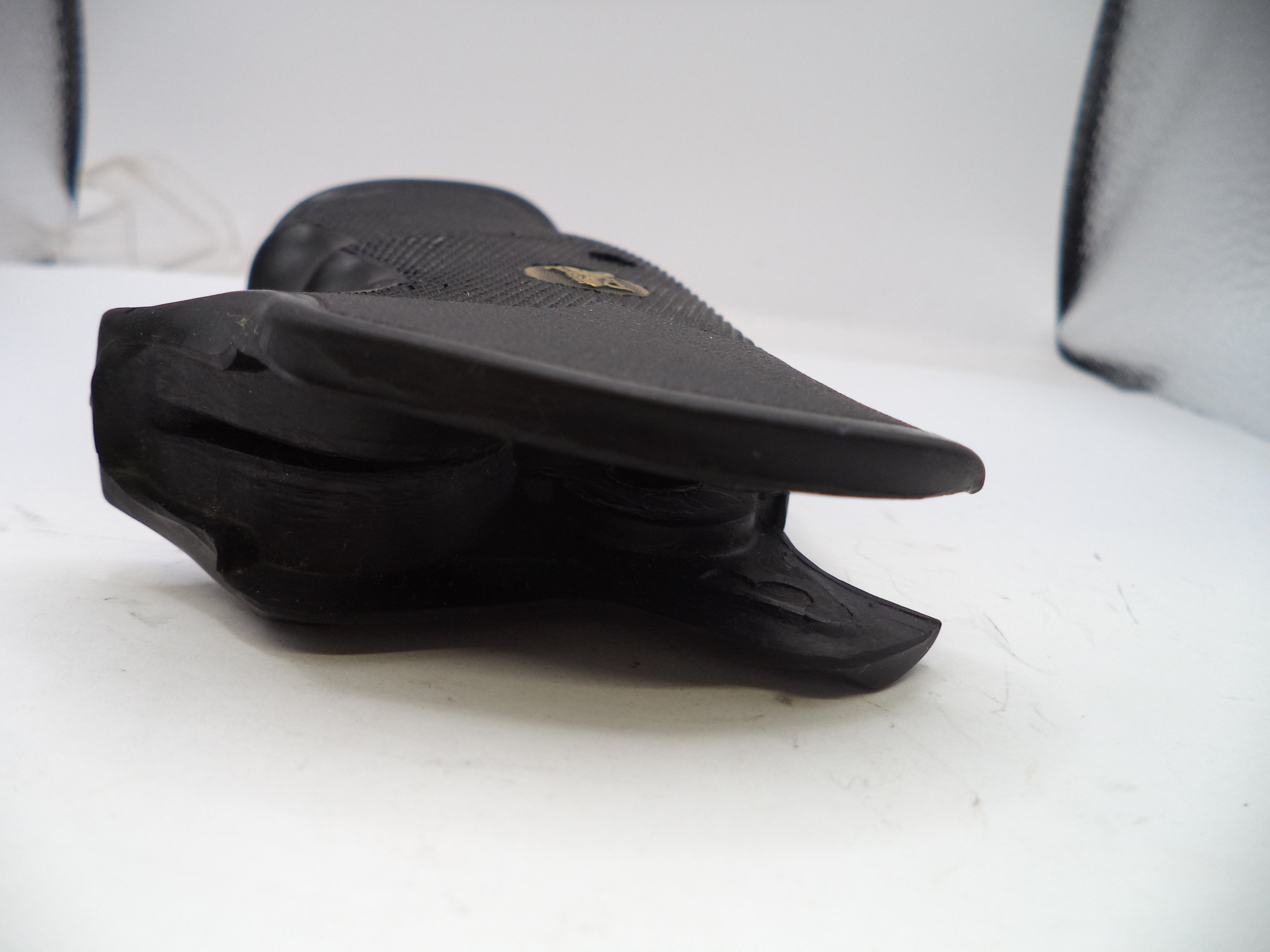 Black sandal with a visible brand logo on a white surface