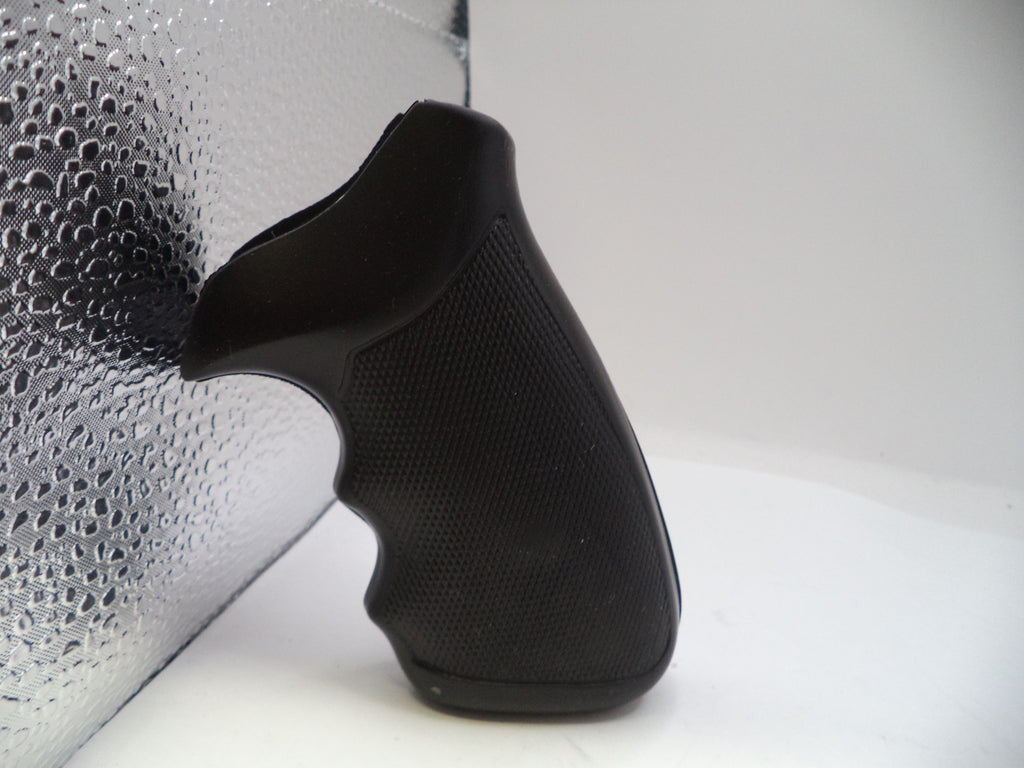 Black slip-on shoe on a white surface with a textured gray background