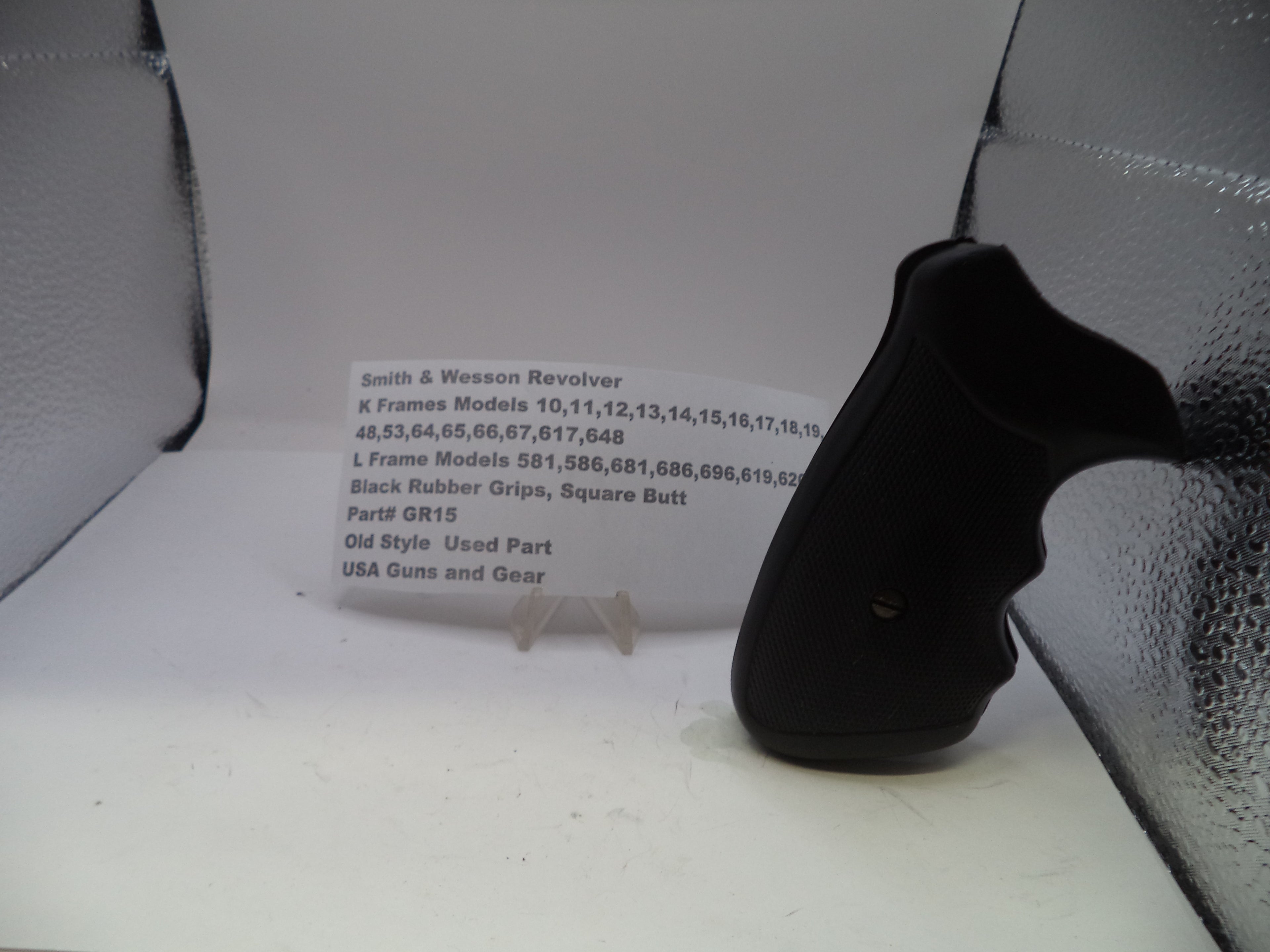 Black revolver grip on a white surface with text in the background