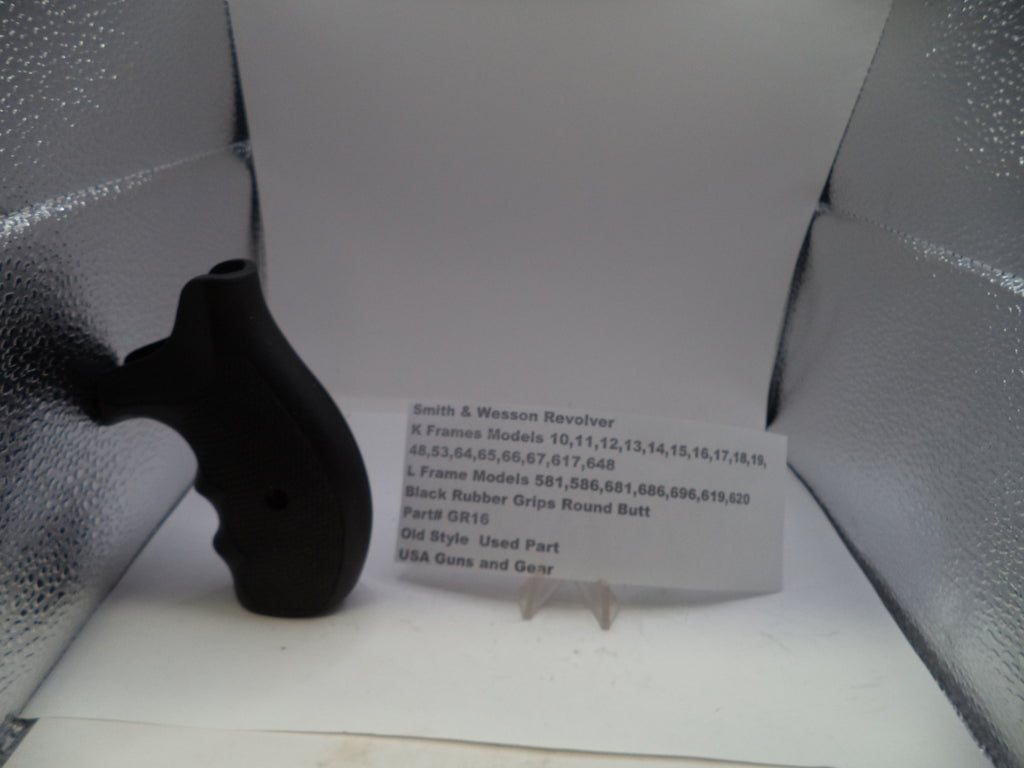Black gun grip on a white surface with a label in front