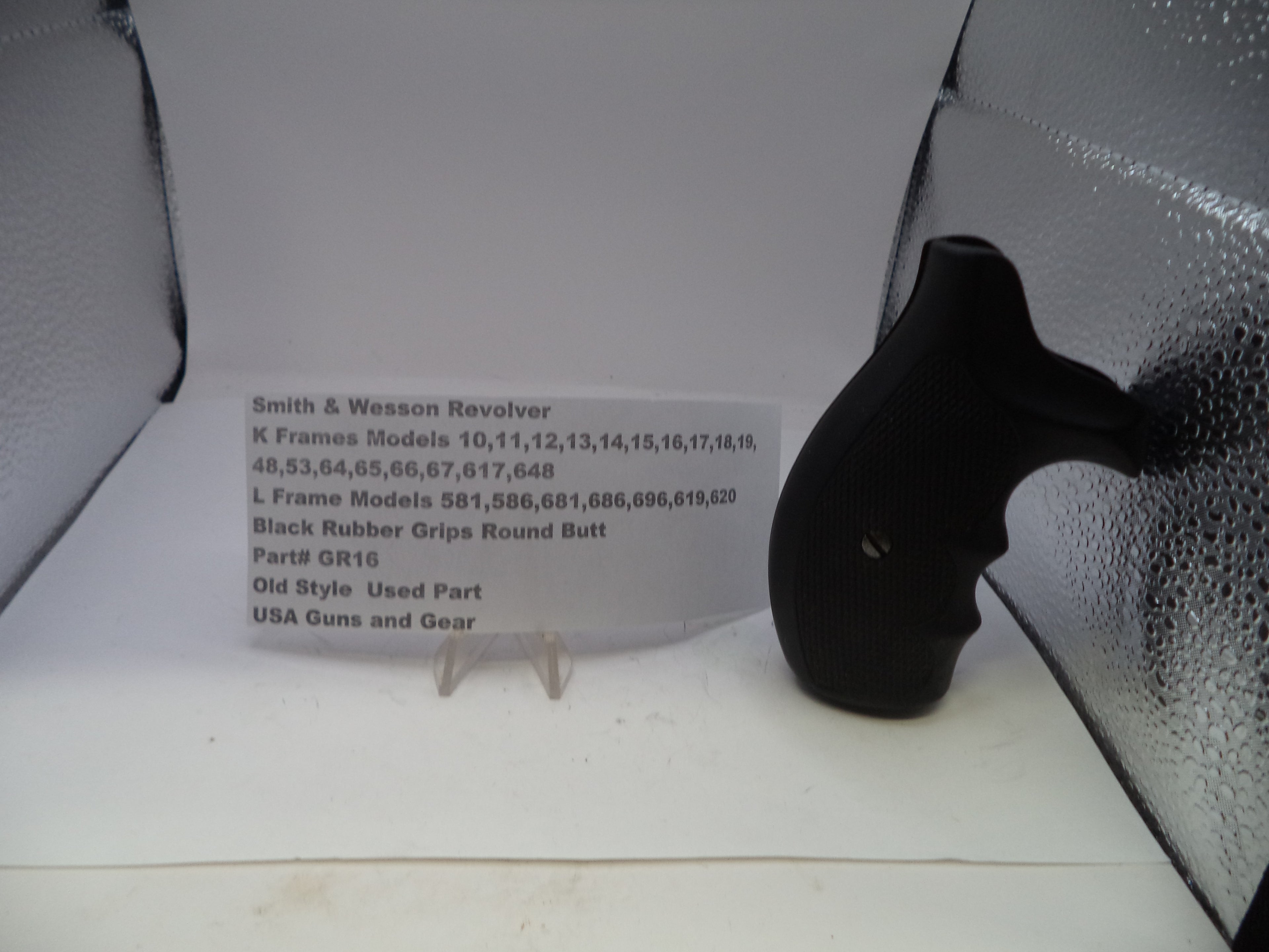 Black rubber grip on a stand with descriptive card in a gray case