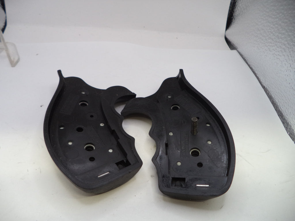 Two black plastic components on a white surface