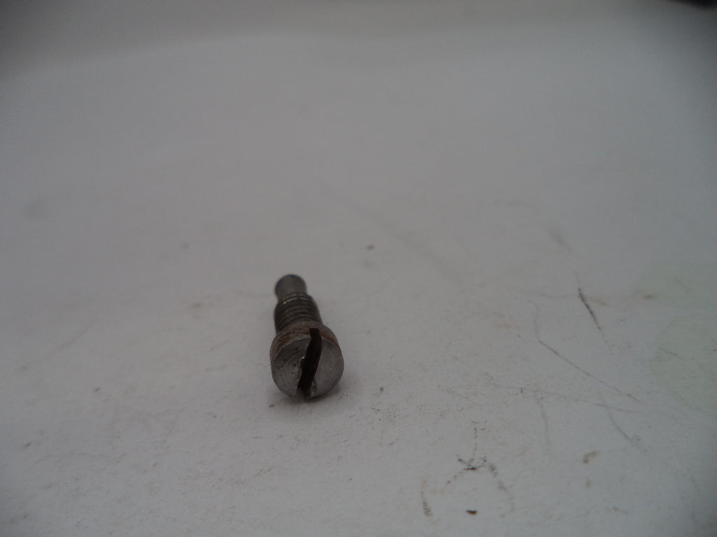 Metal screw on a white surface with visible wear