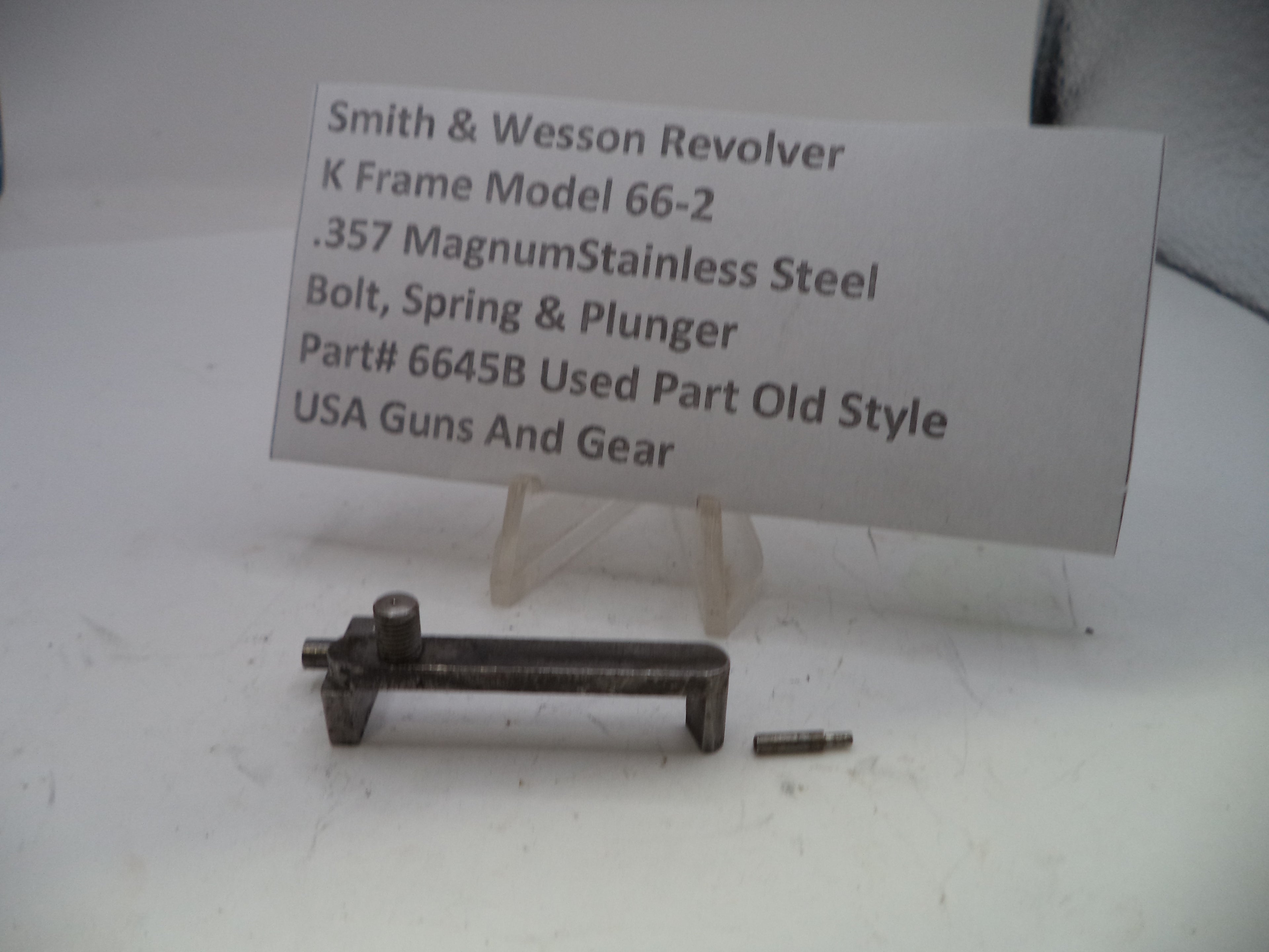Smith & Wesson revolver parts on a white background with a label.