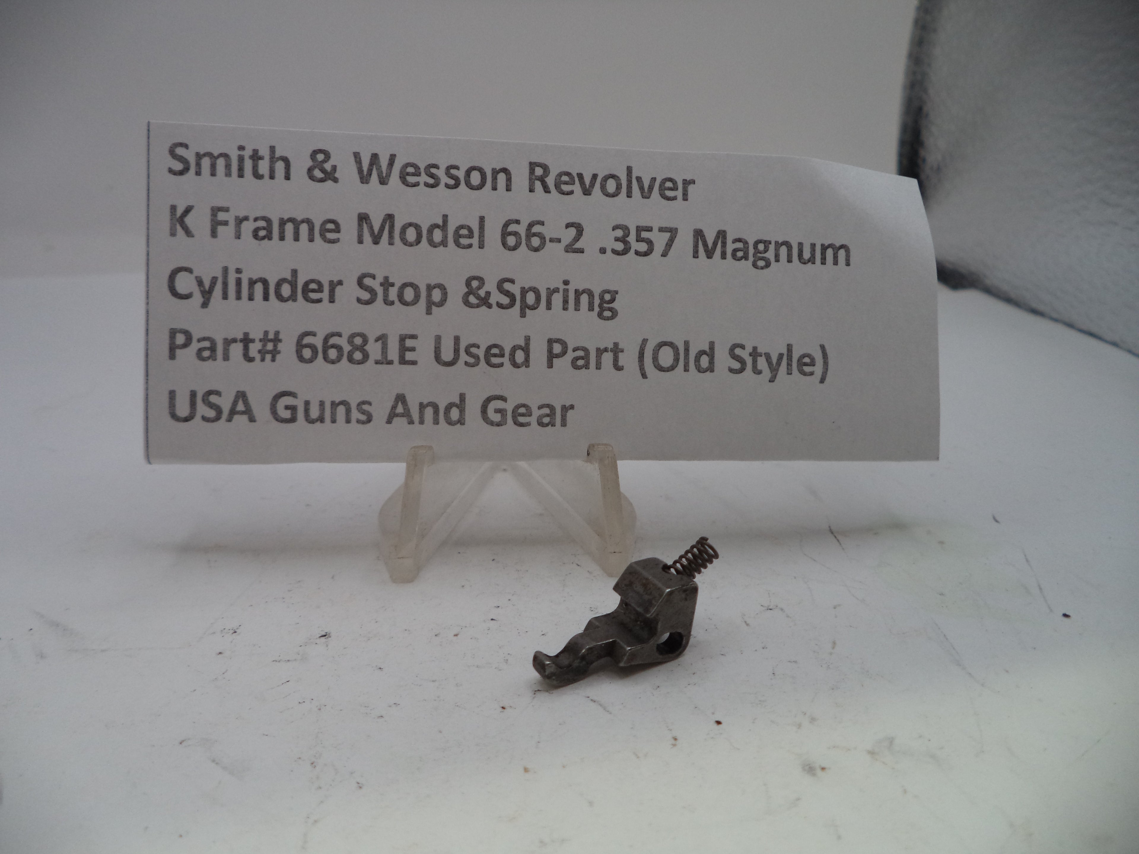 Smith & Wesson revolver part with descriptive card on a white background