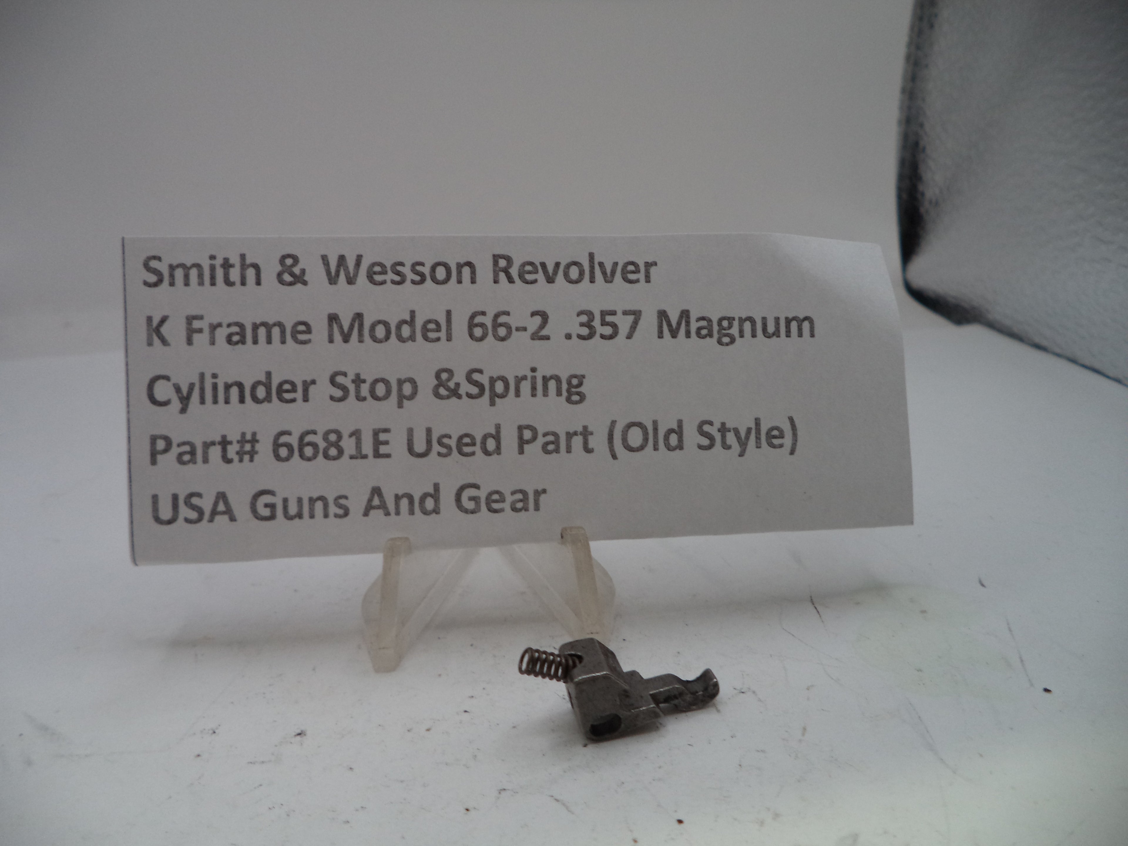 Smith & Wesson revolver cylinder stop and spring on a white background with a label.