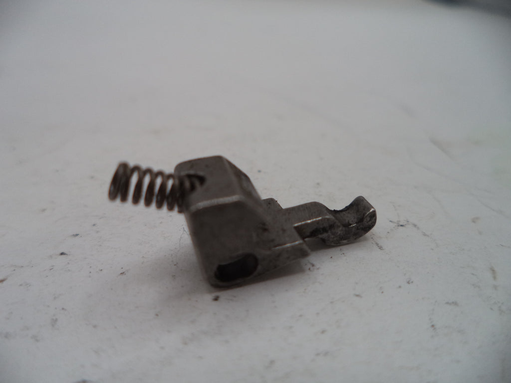 Metal component with a spring on a white surface