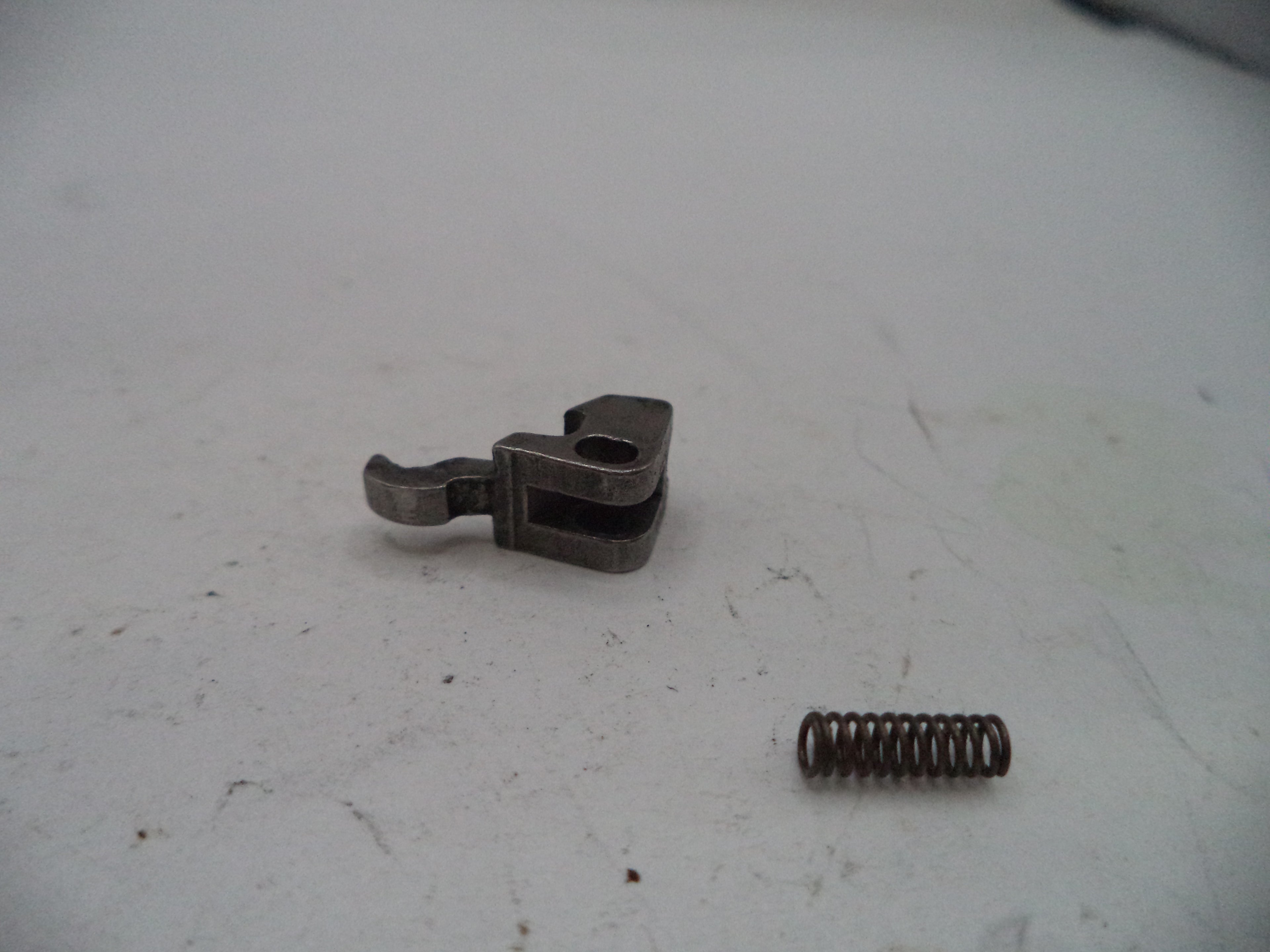 Metal clip and spring on a white surface