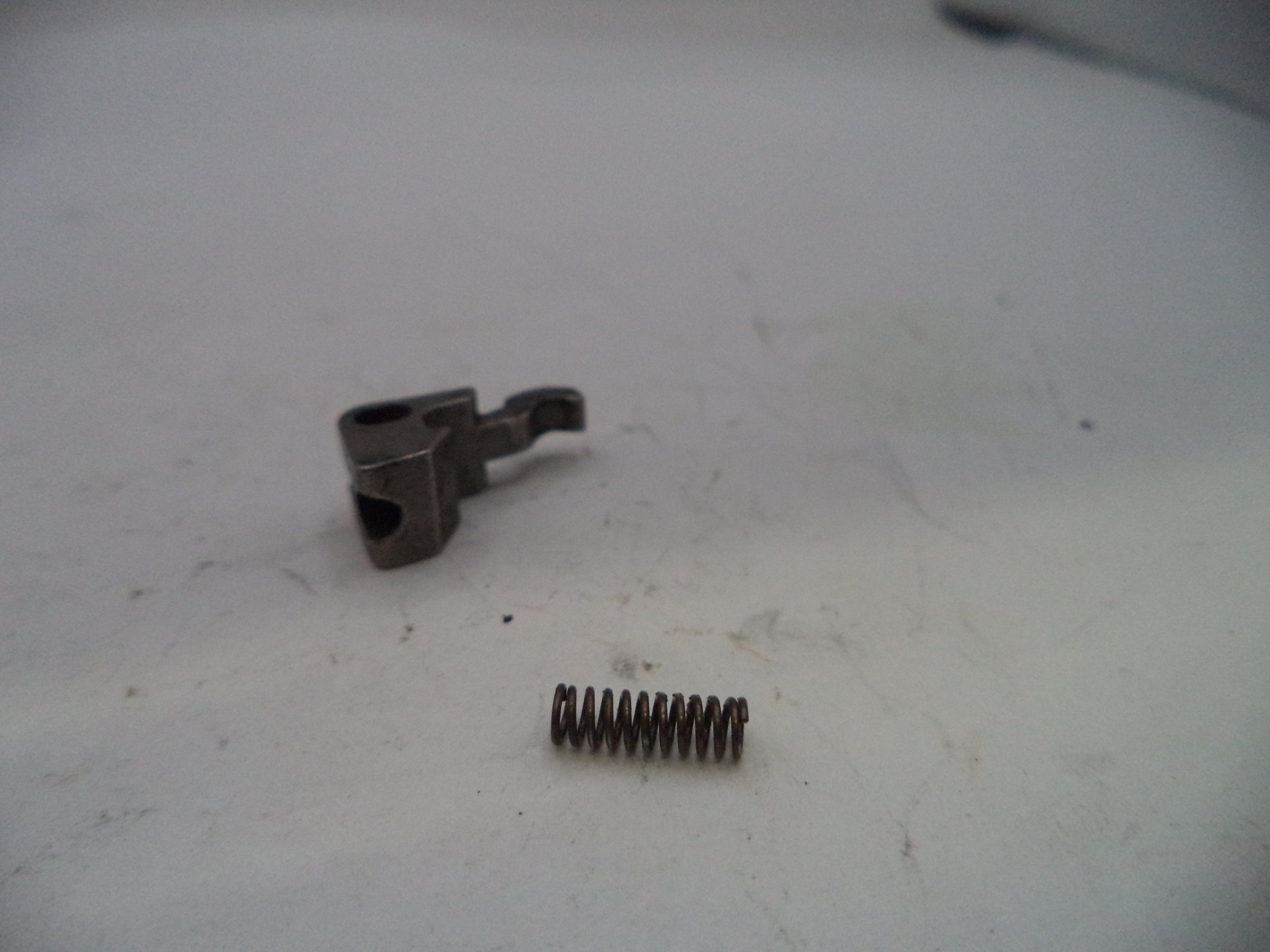 Two metal components on a white surface