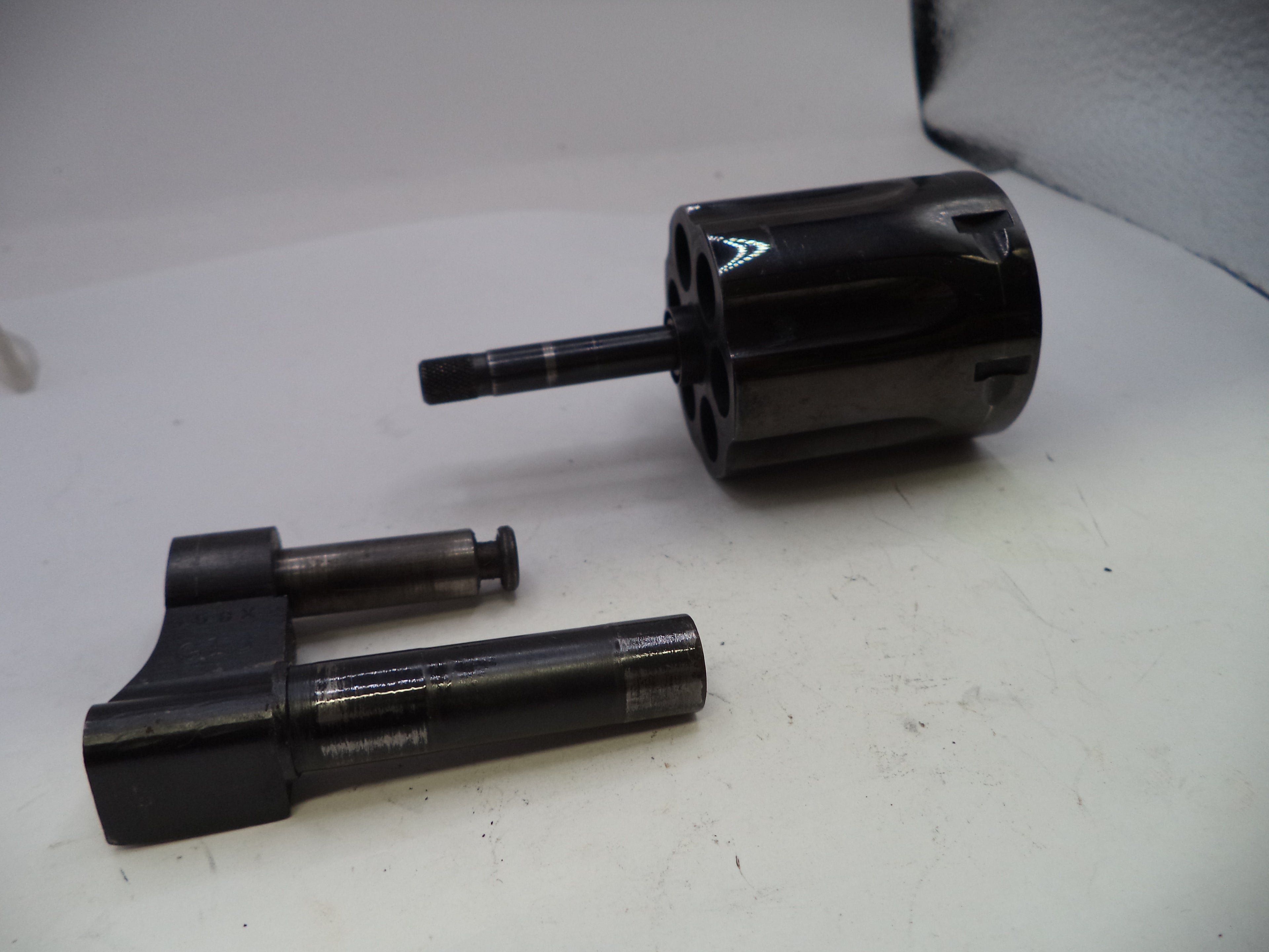 Two black mechanical components on a white surface