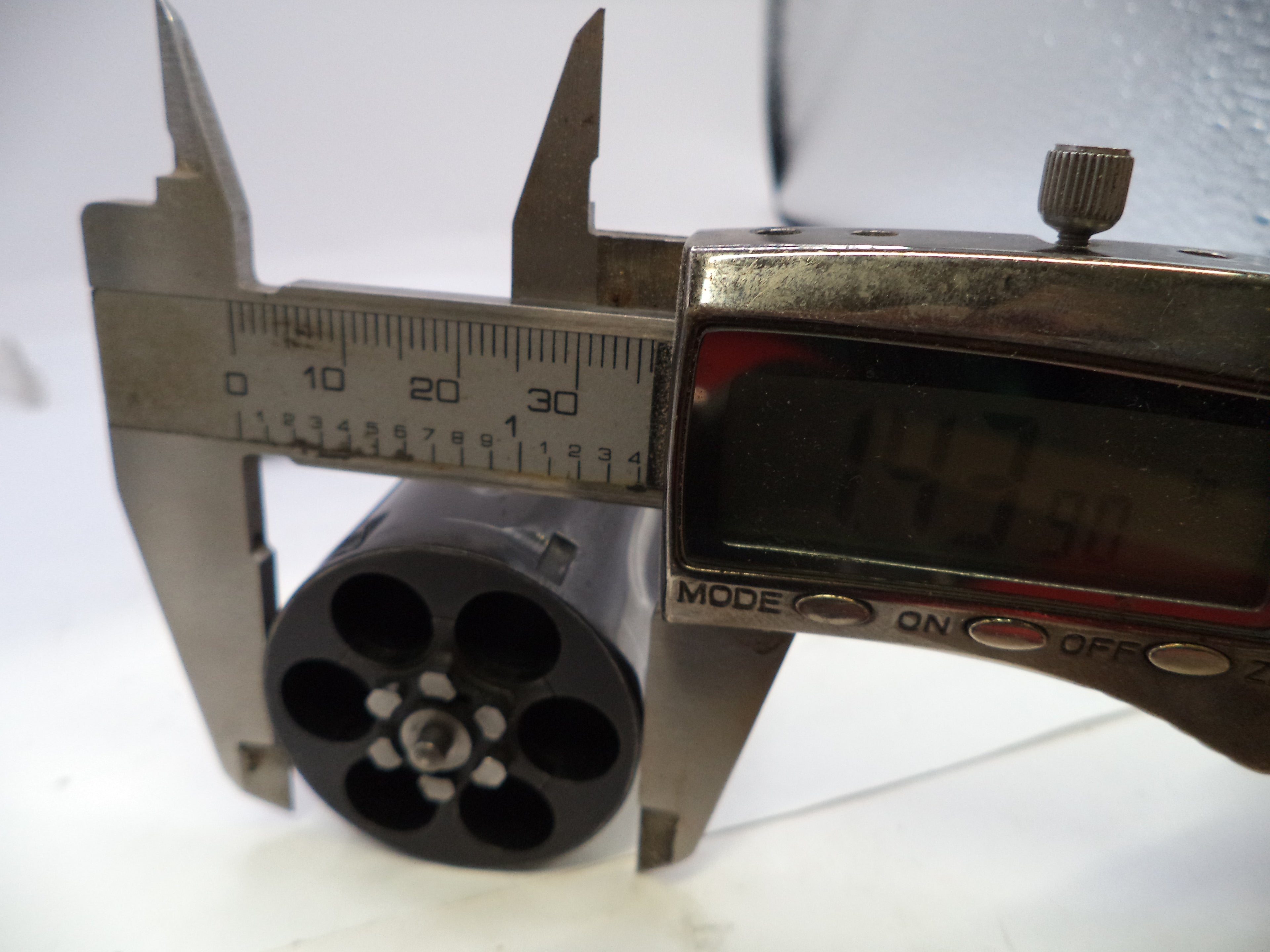 Caliper measuring a cylindrical object with a digital display