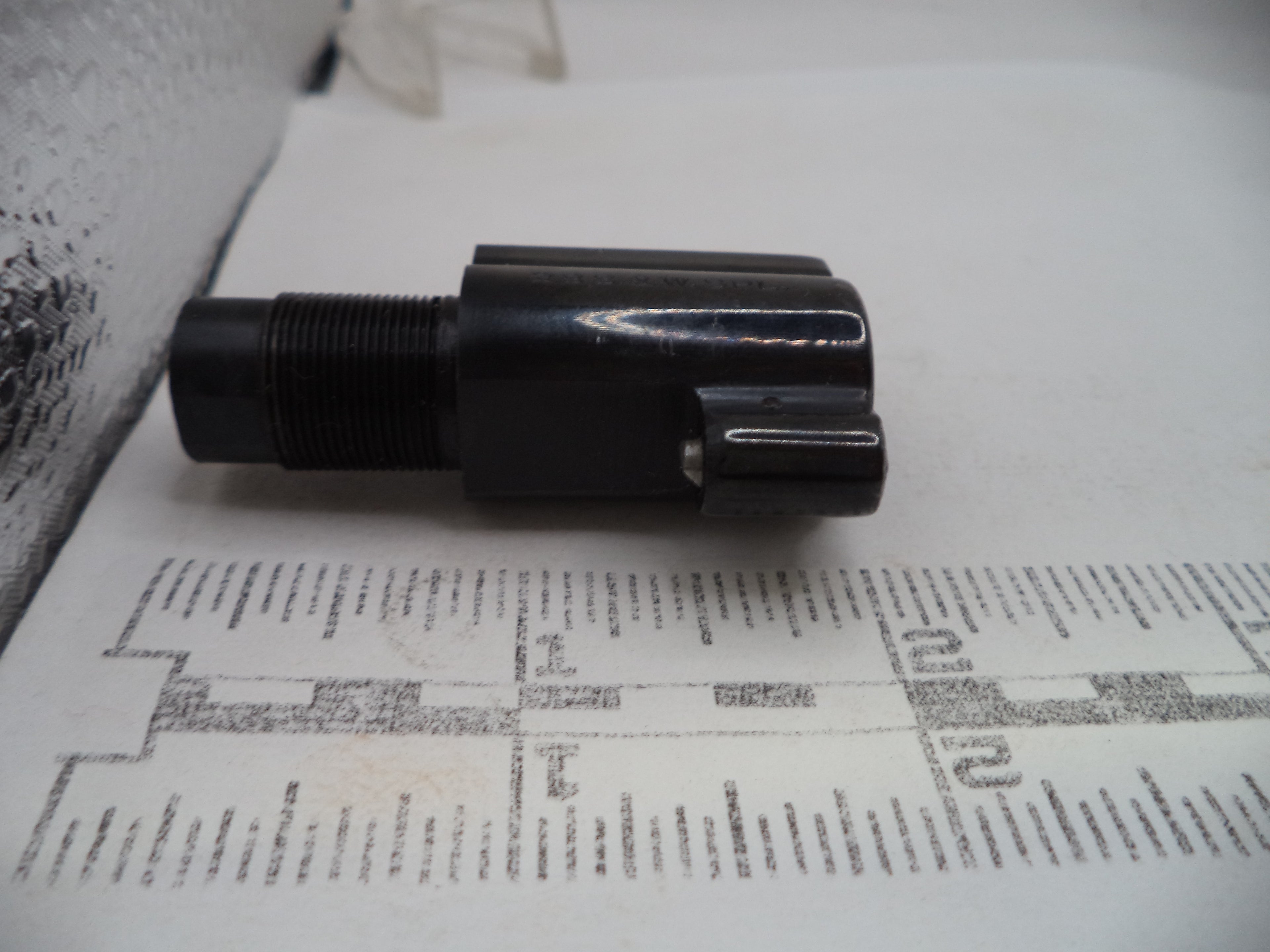 Black cylindrical object on a printed paper background