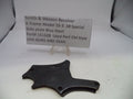 Black side plate for a Smith & Wesson revolver on a white background with a label.