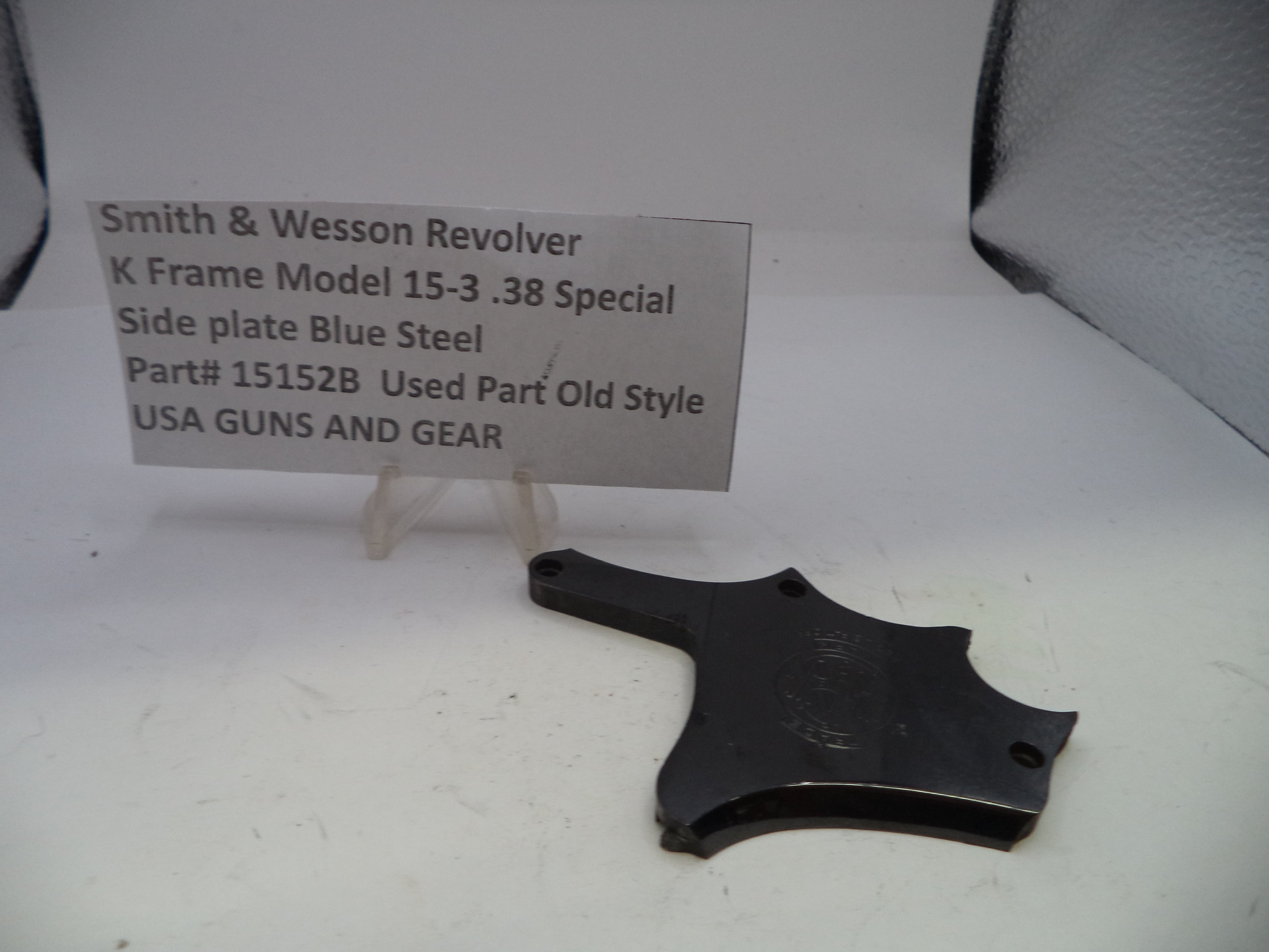 Smith & Wesson revolver side plate on a white surface with a label