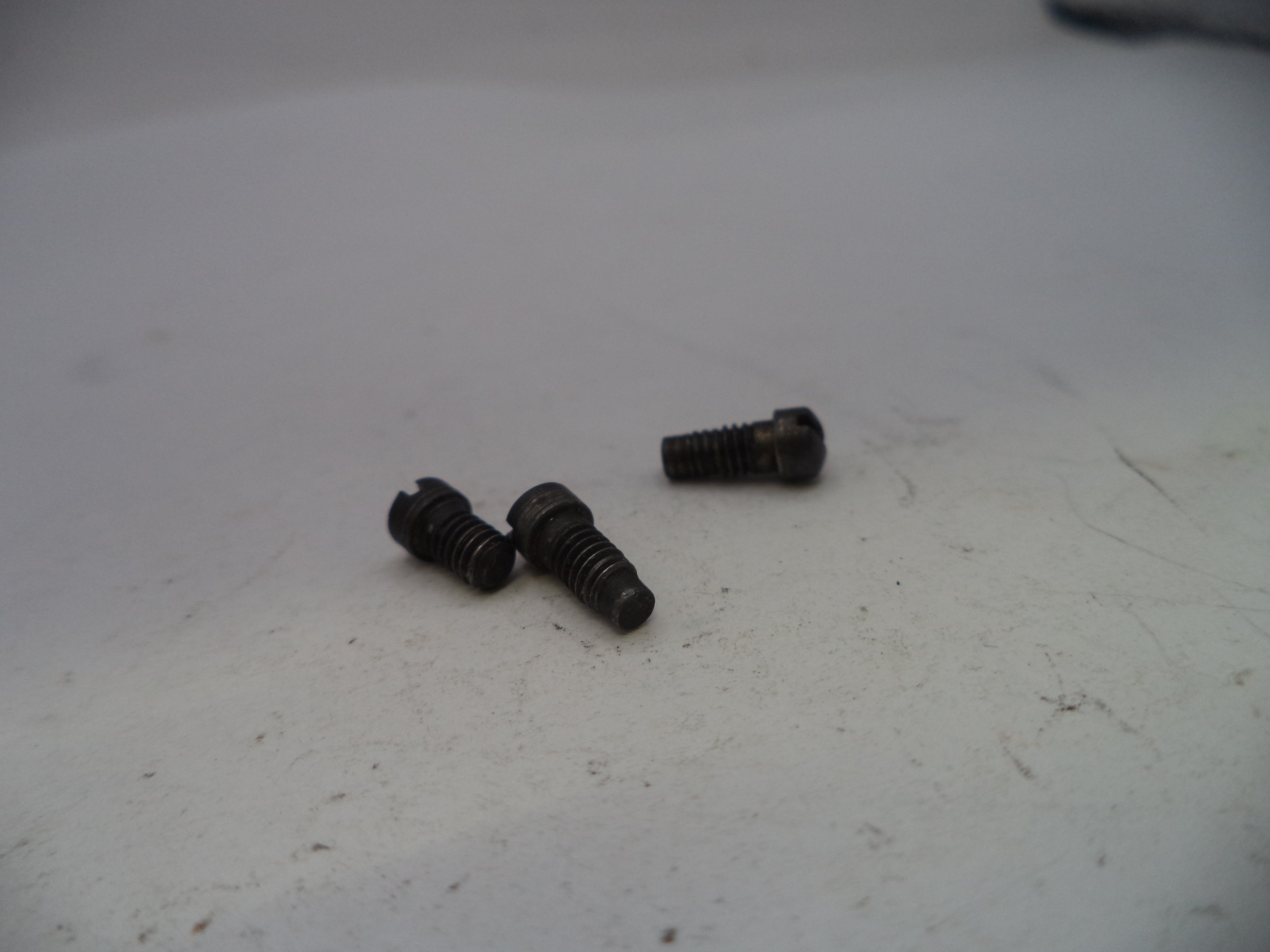 Three black screws on a white surface