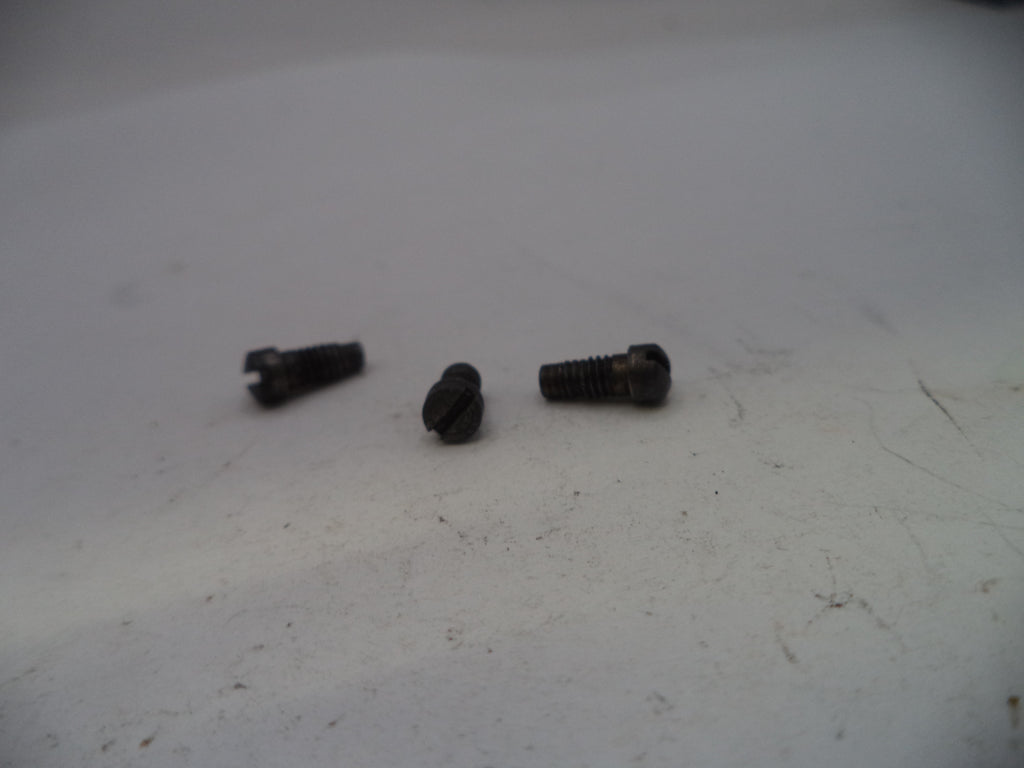 Three small black screws on a white surface