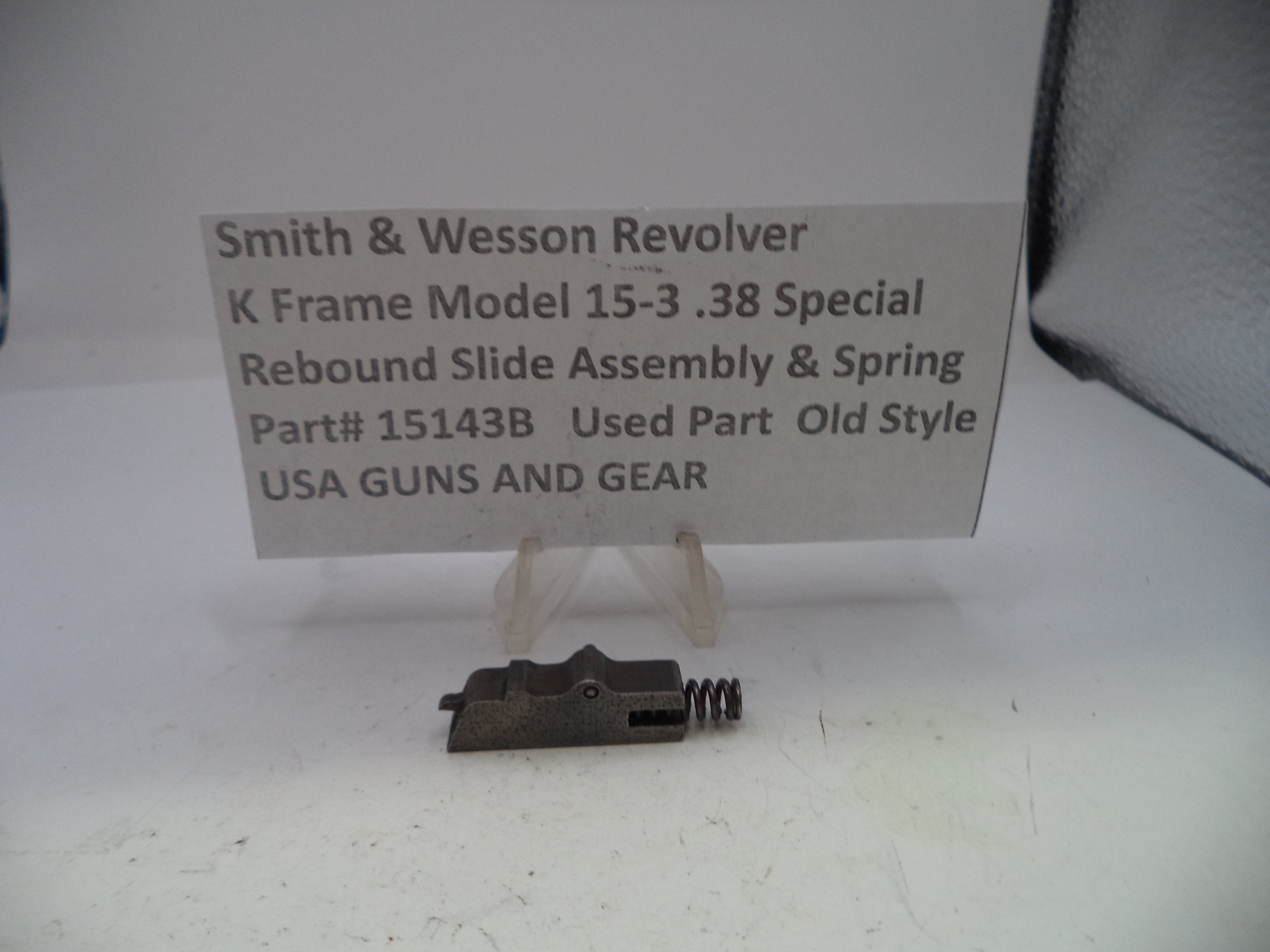 Smith & Wesson revolver part with descriptive card on a white background