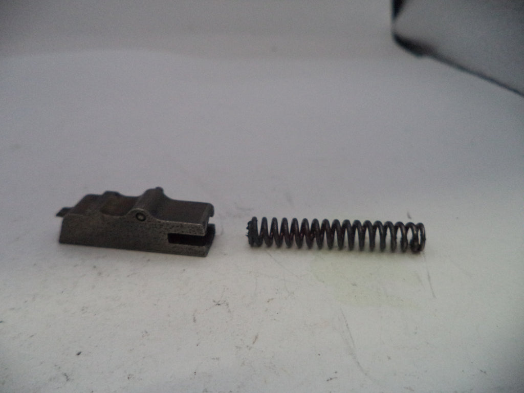 Metal component and spring on a white surface