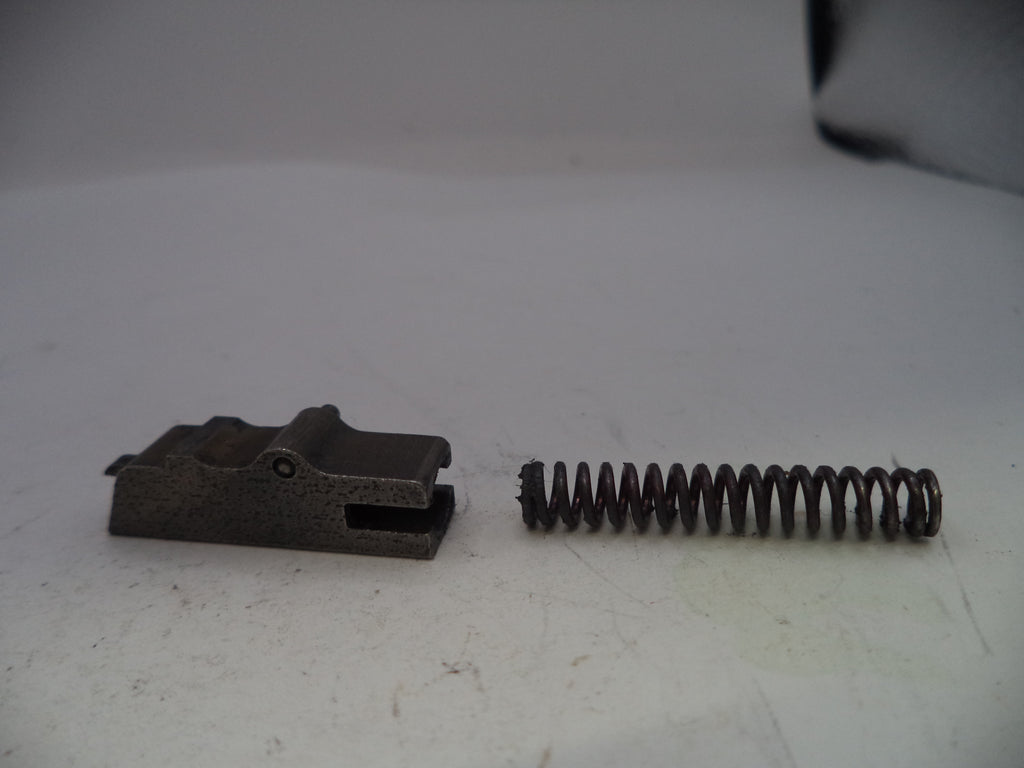 Metal brake pad and spring on a white surface