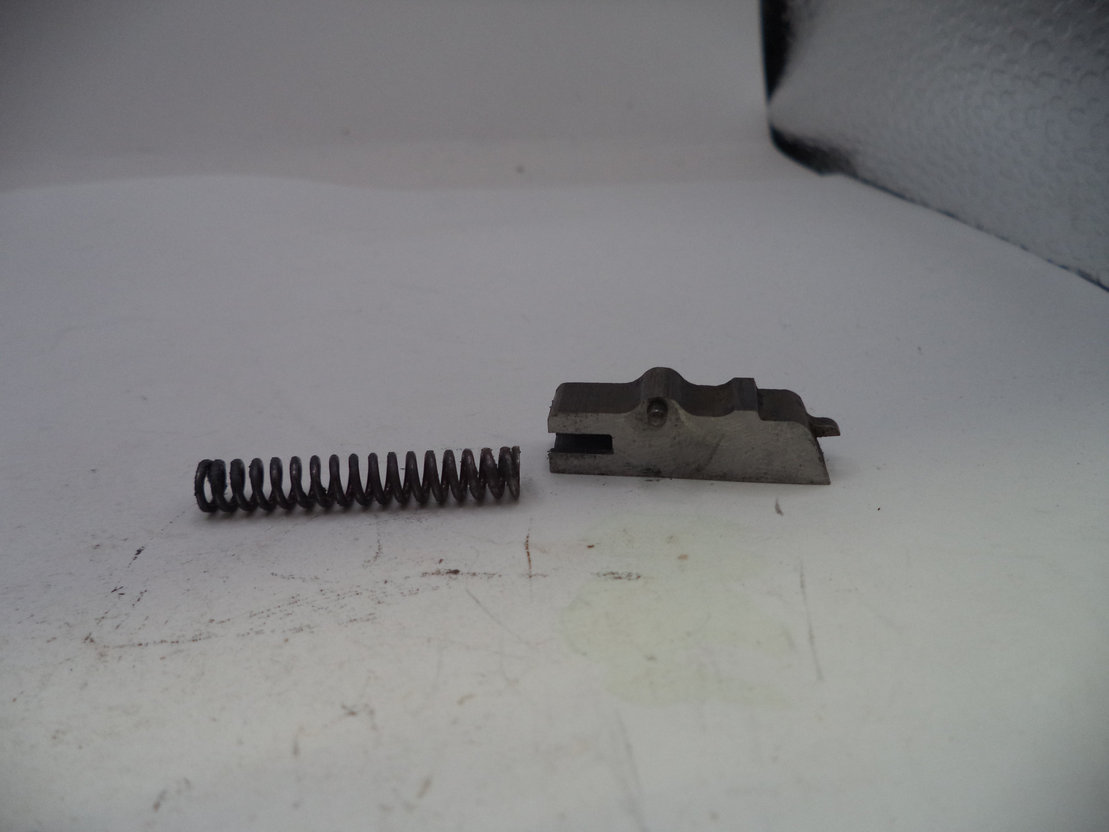 Metal spring and mechanical component on a white surface