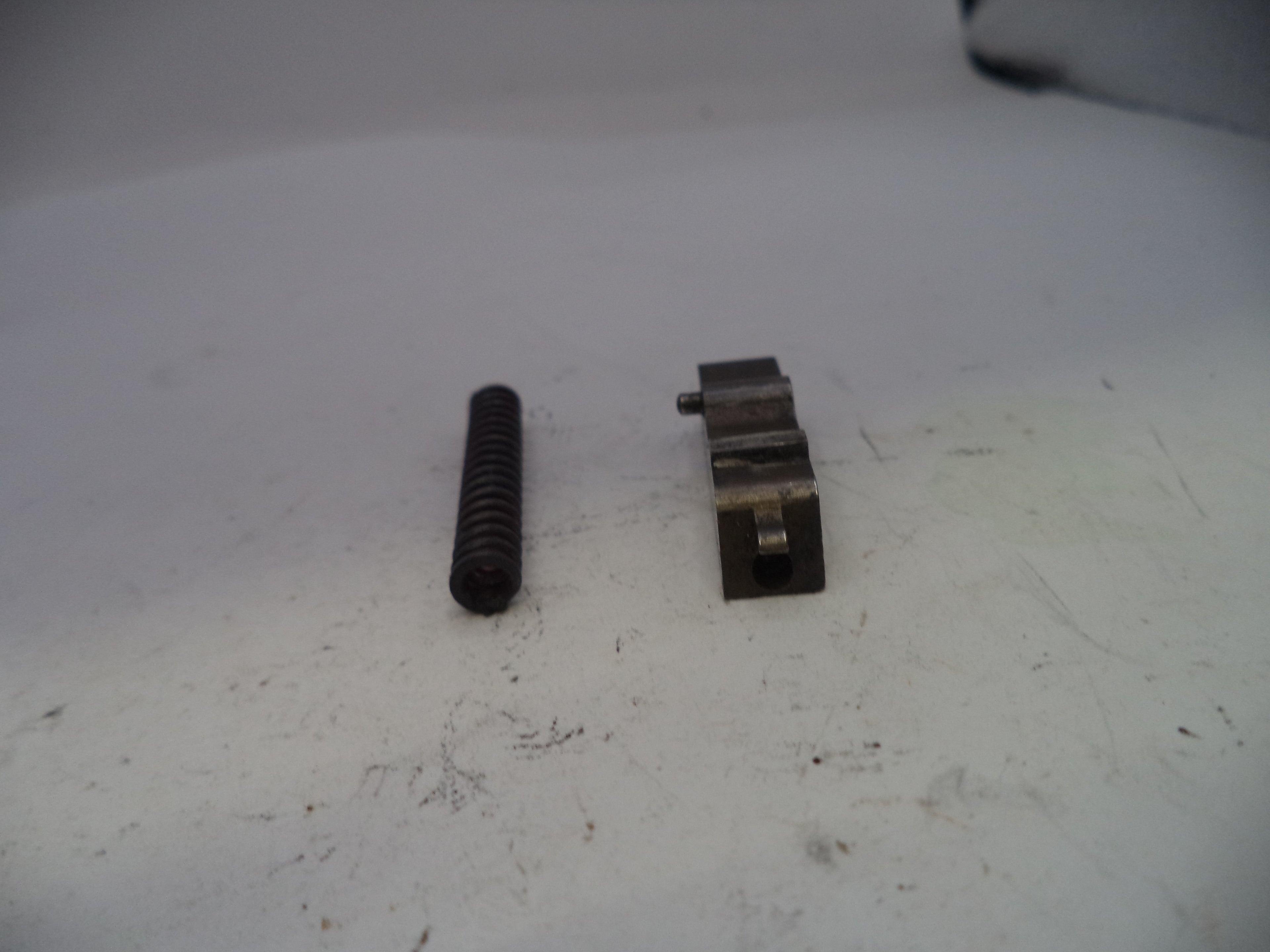 Two metal components on a white surface