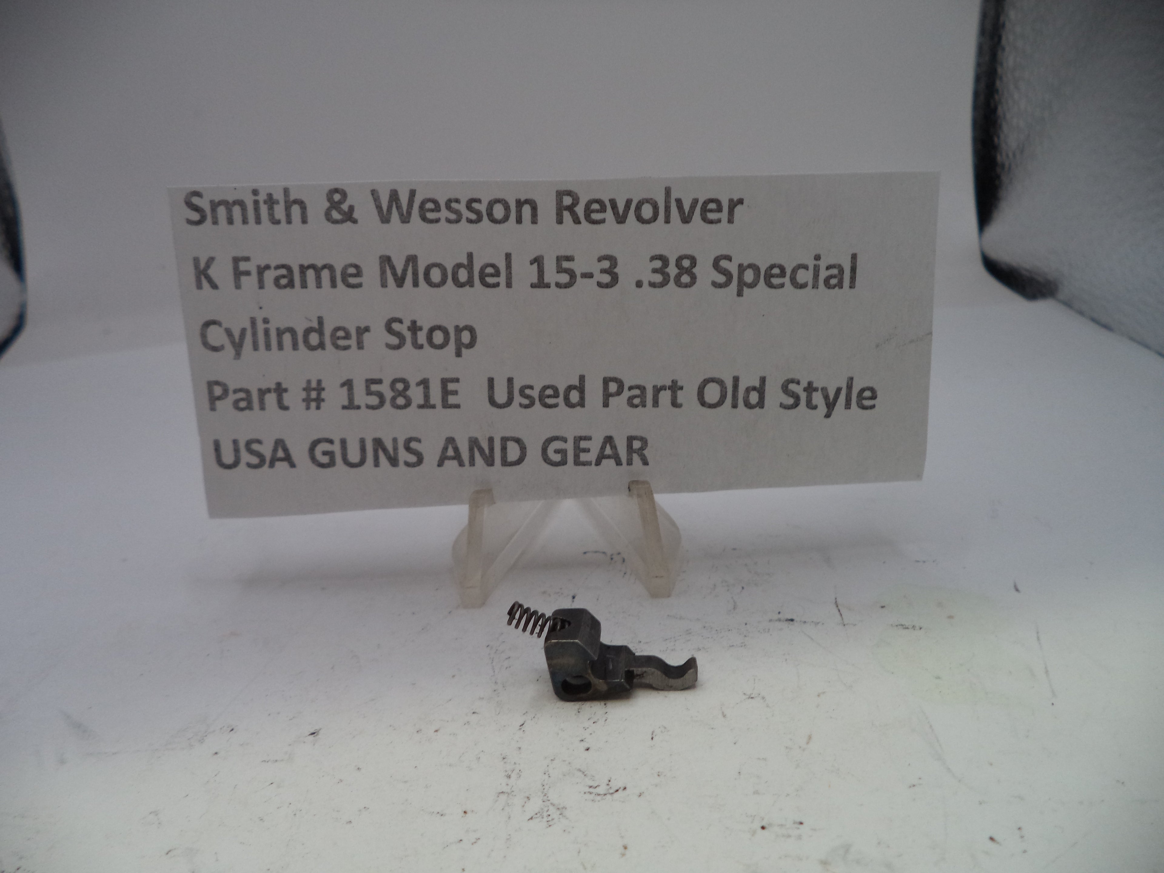 Smith & Wesson revolver cylinder stop part on a white background with descriptive text card.