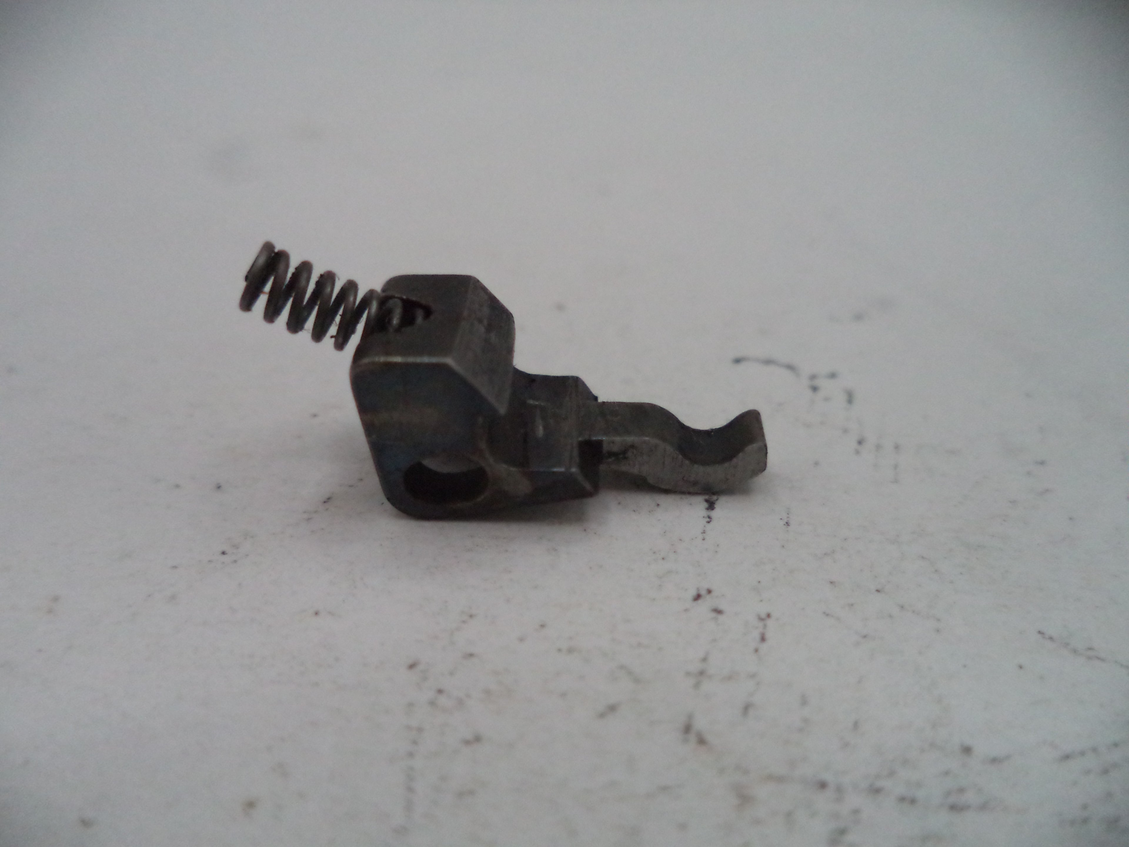 Metal spring and mechanical component on a light gray surface